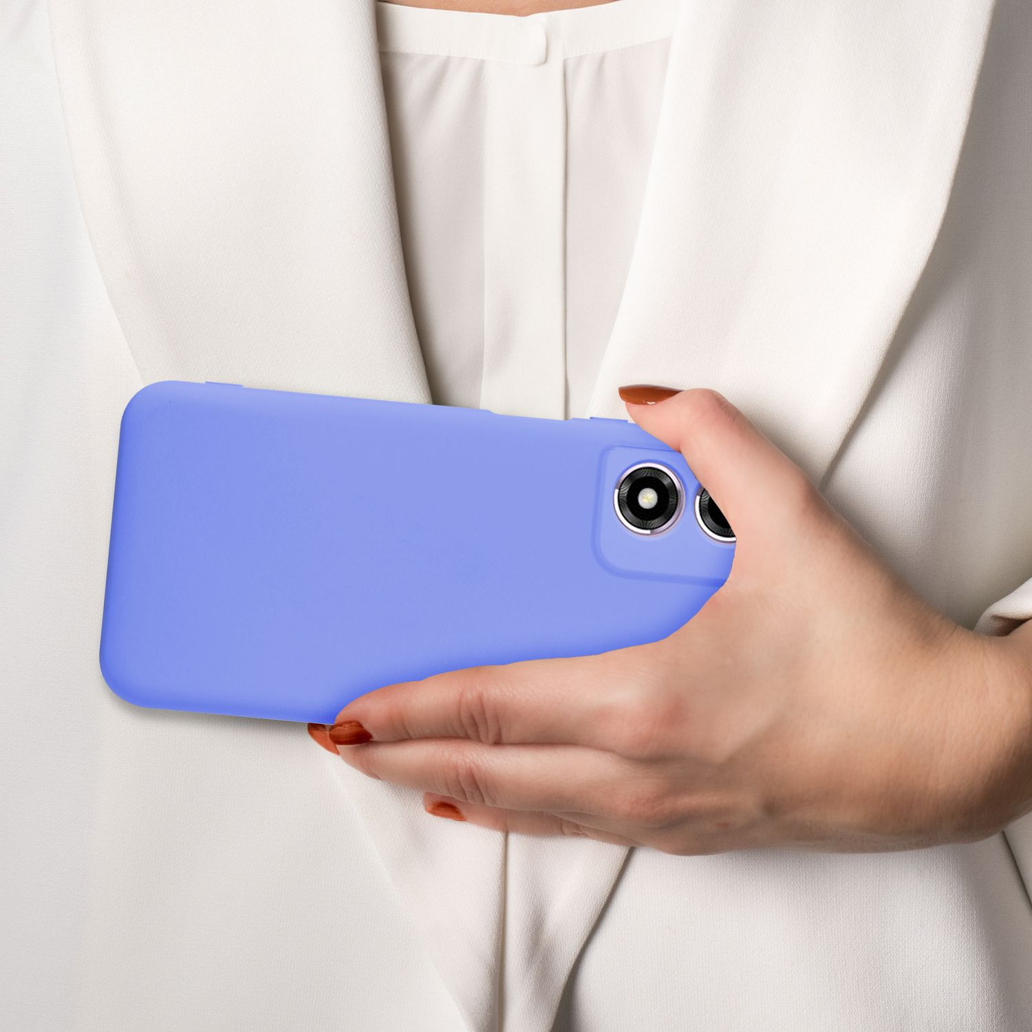 Eine Person hält ein lila Telefon vor ihre Brust. Die Person trägt ein weißes Hemd.