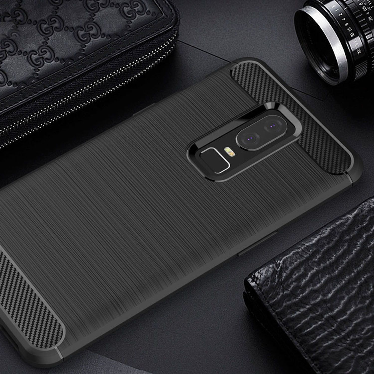 Primer plano de una funda negra con diseño texturizado y detalles de fibra de carbono. Fondo oscuro.