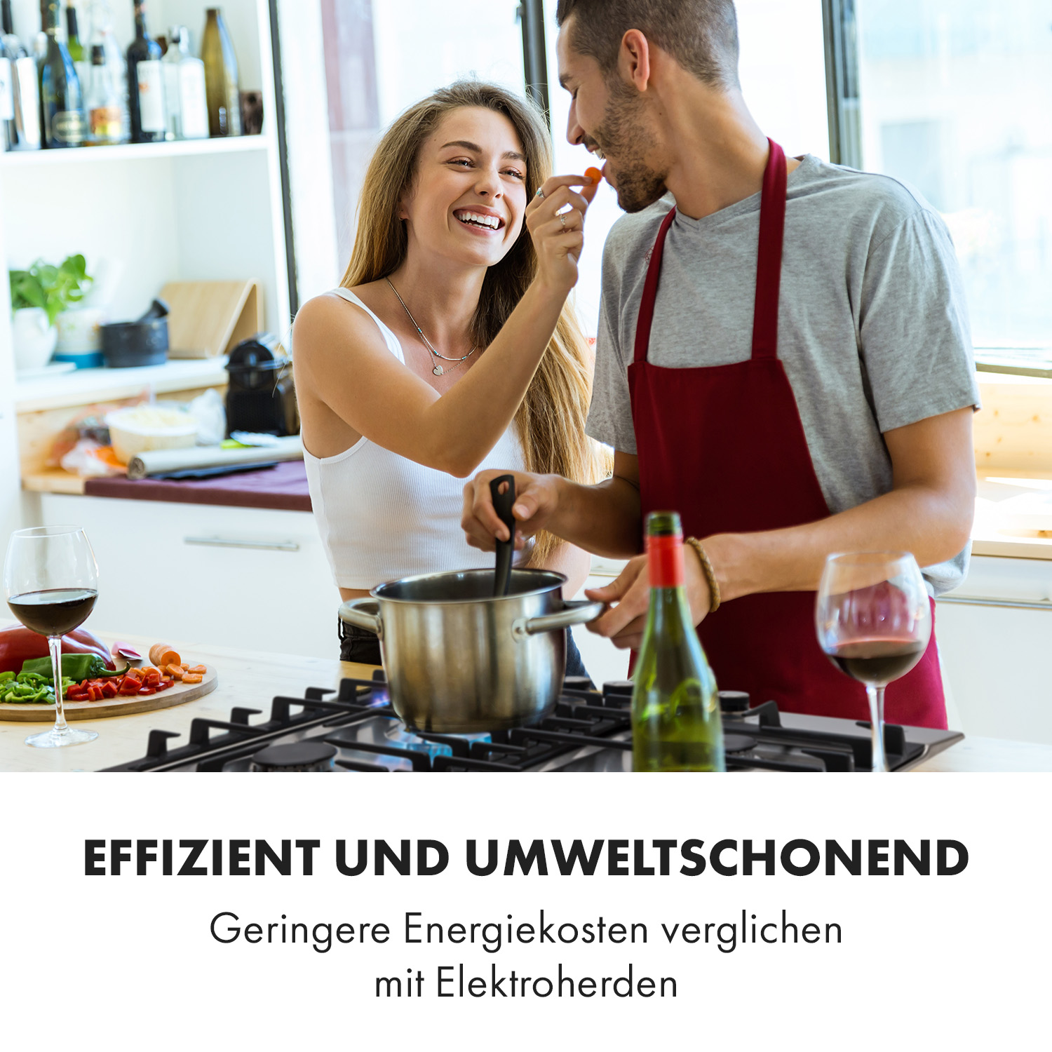 Paar in der Küche. Frau füttert Mann, während er auf einem Gasherd kocht. Text: Effizient und umweltschonend.
