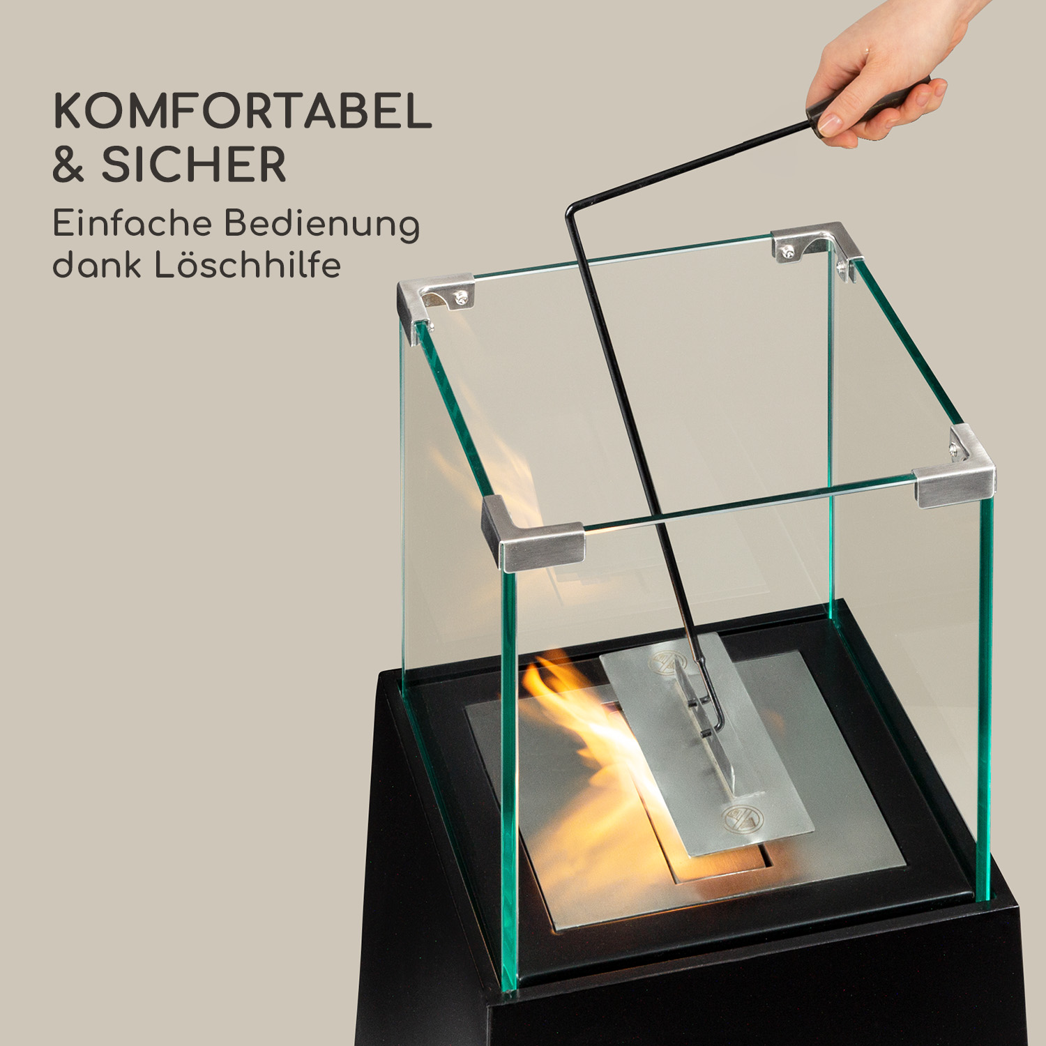 Ein Glas-Kamin mit einer Hand, die den Feuerlöscher hält. Die Flamme ist entzündet.