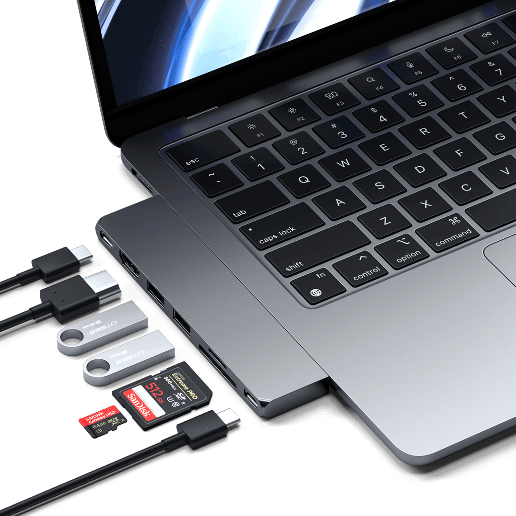 Laptop z podłączonymi dyskami USB i kartami SD. Skupienie na laptopie i urządzeniach peryferyjnych.