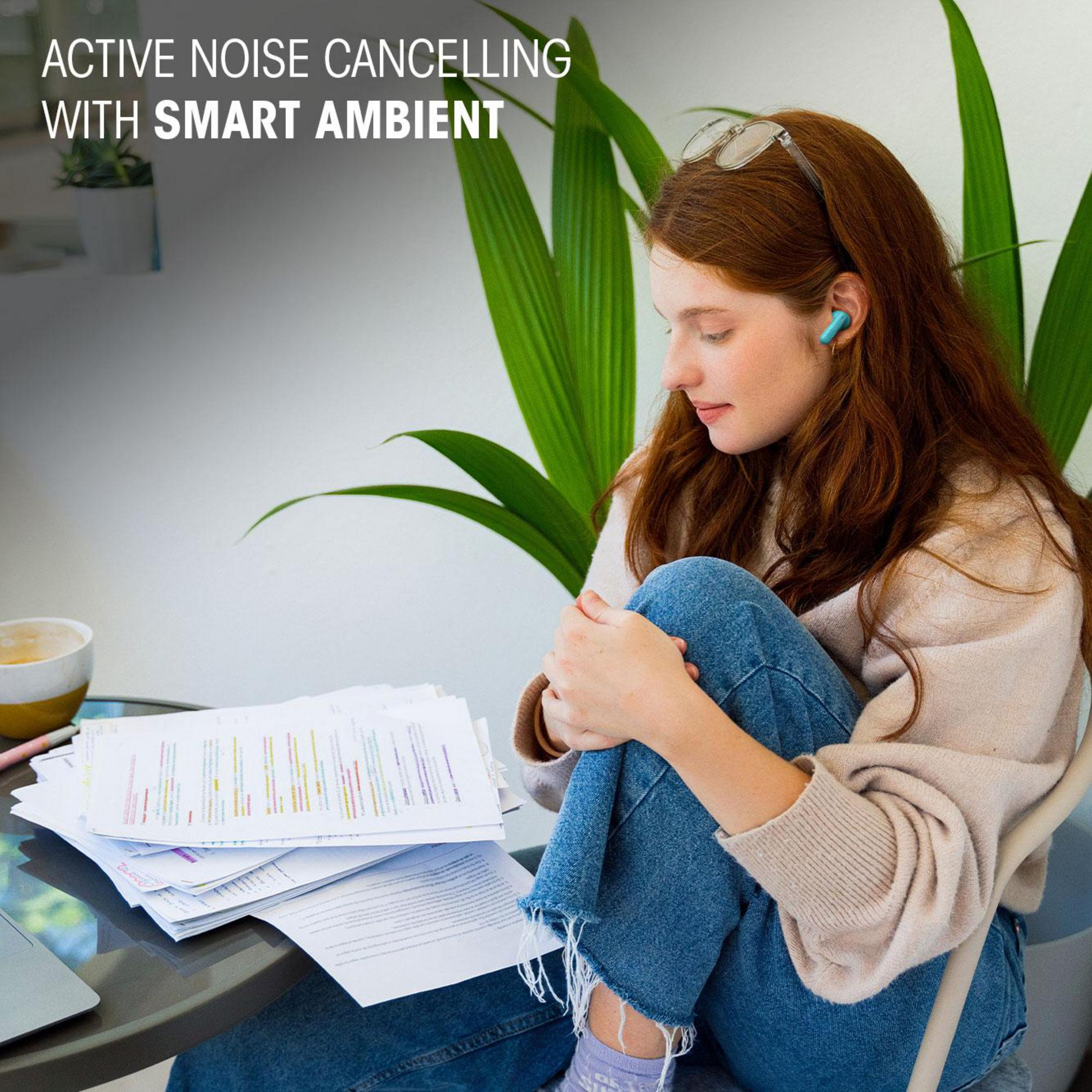 Kobieta z rudymi włosami w słuchawkach, przy roślinie, siedząca.