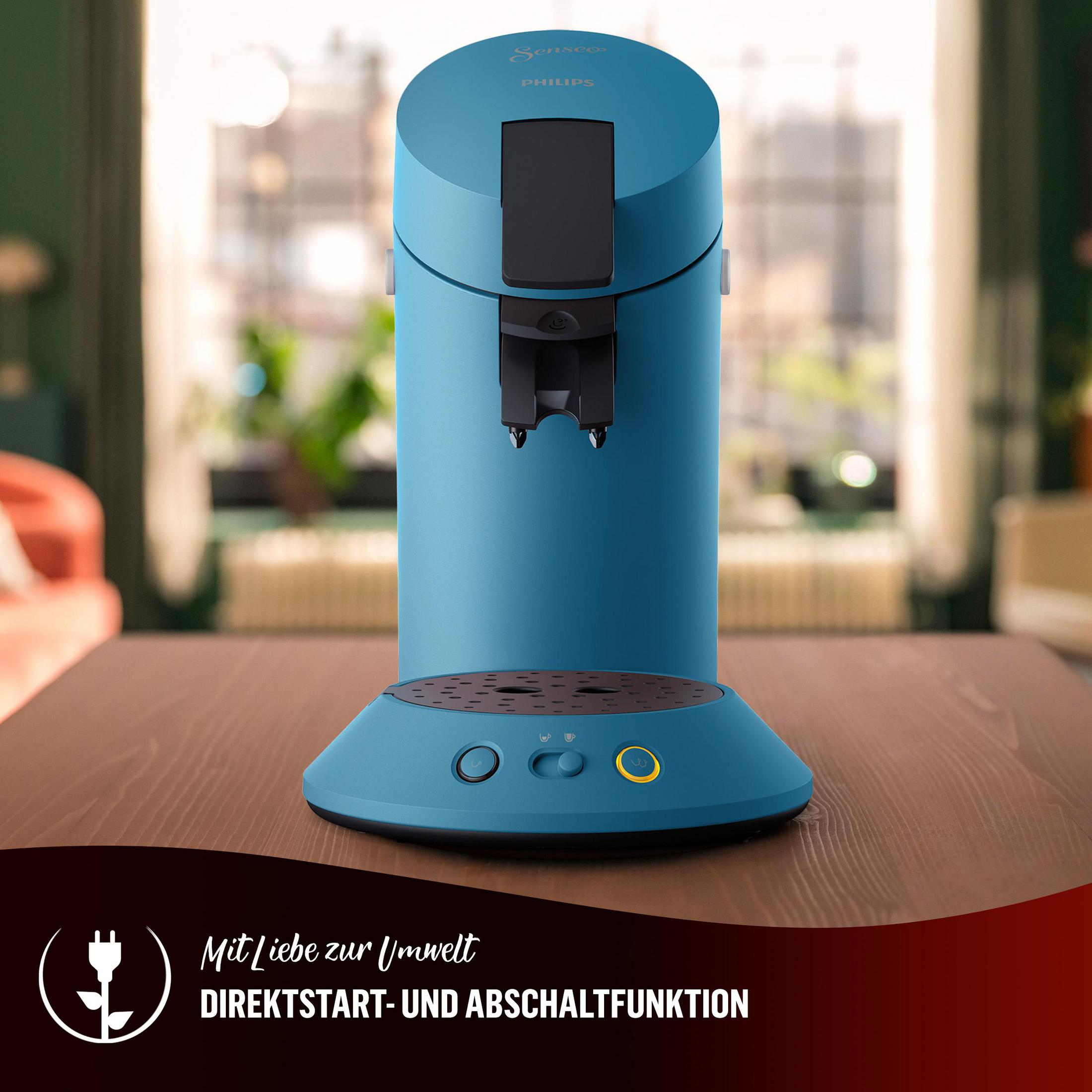 Blaue Kaffeemaschine. Die Maschine steht auf einem Holztisch. Der Hintergrund ist unscharf.