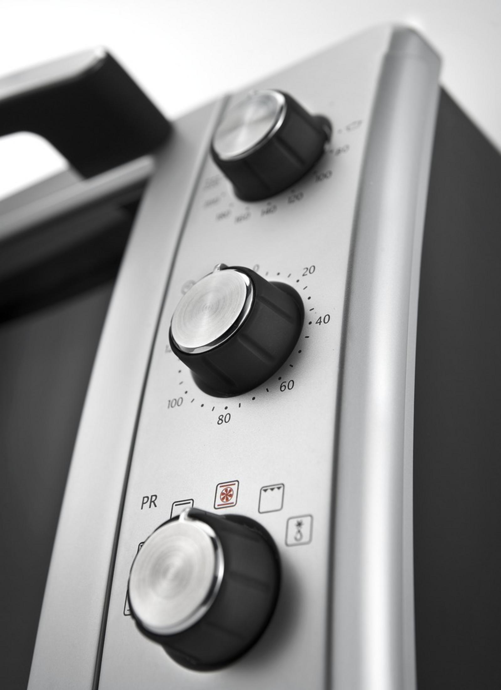 Primo piano dei controlli del forno con manopole e icone.