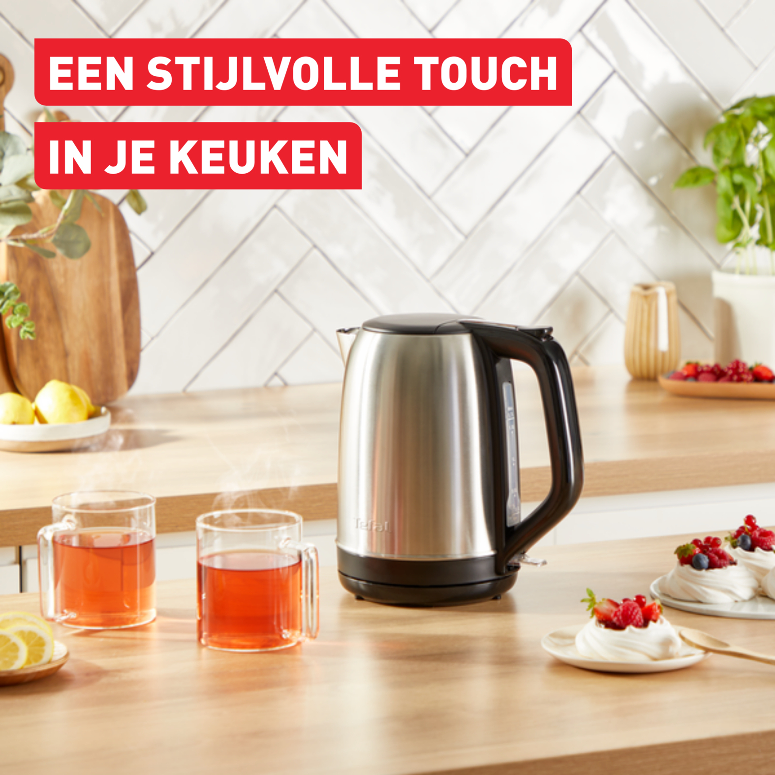 Edelstahl-Wasserkocher auf Holztheke mit Essen und Teetassen. Text-Overlay.