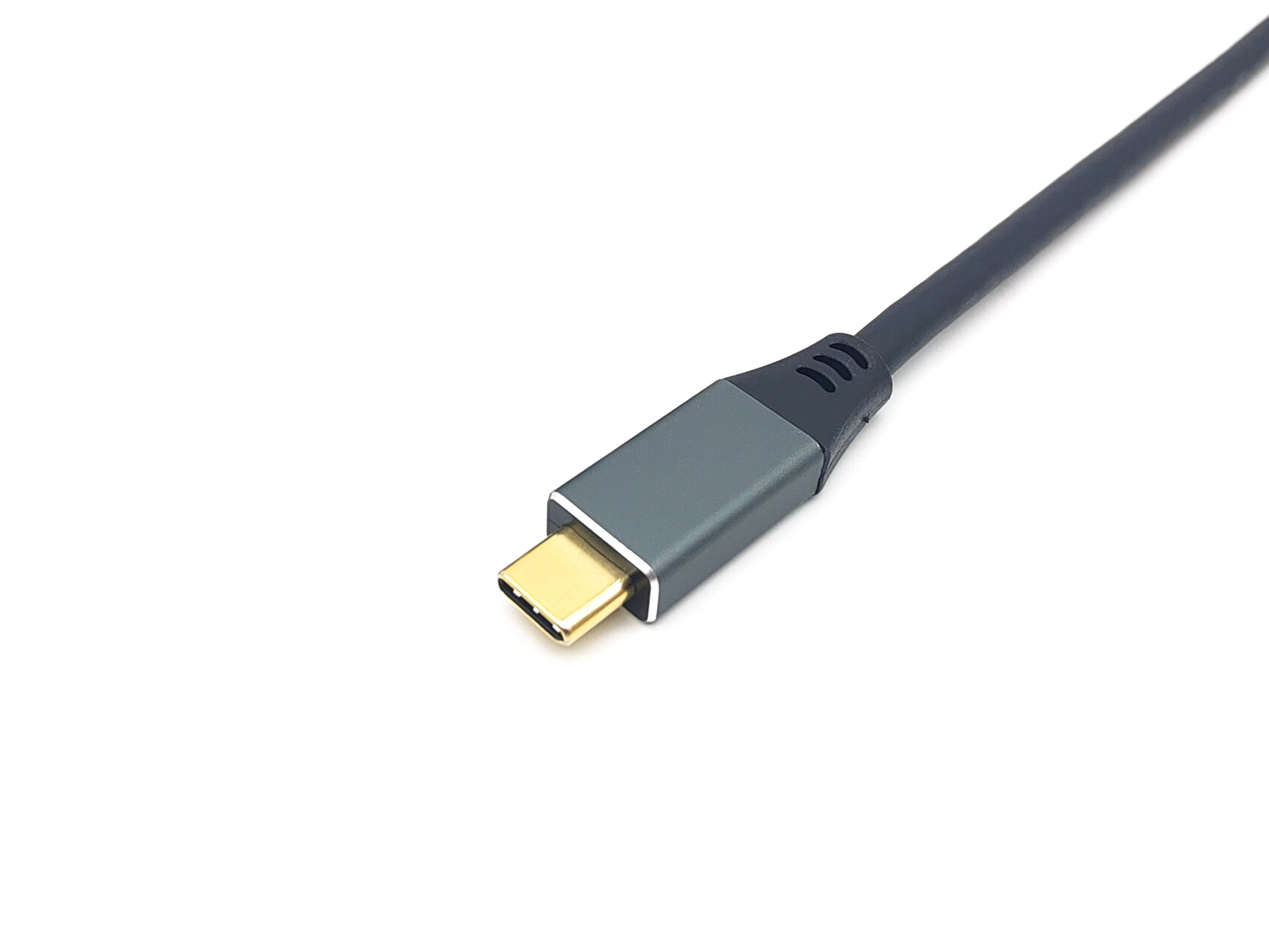 Primer plano de un cable con conector USB-C. El conector es gris con un puerto dorado. Fondo blanco.
