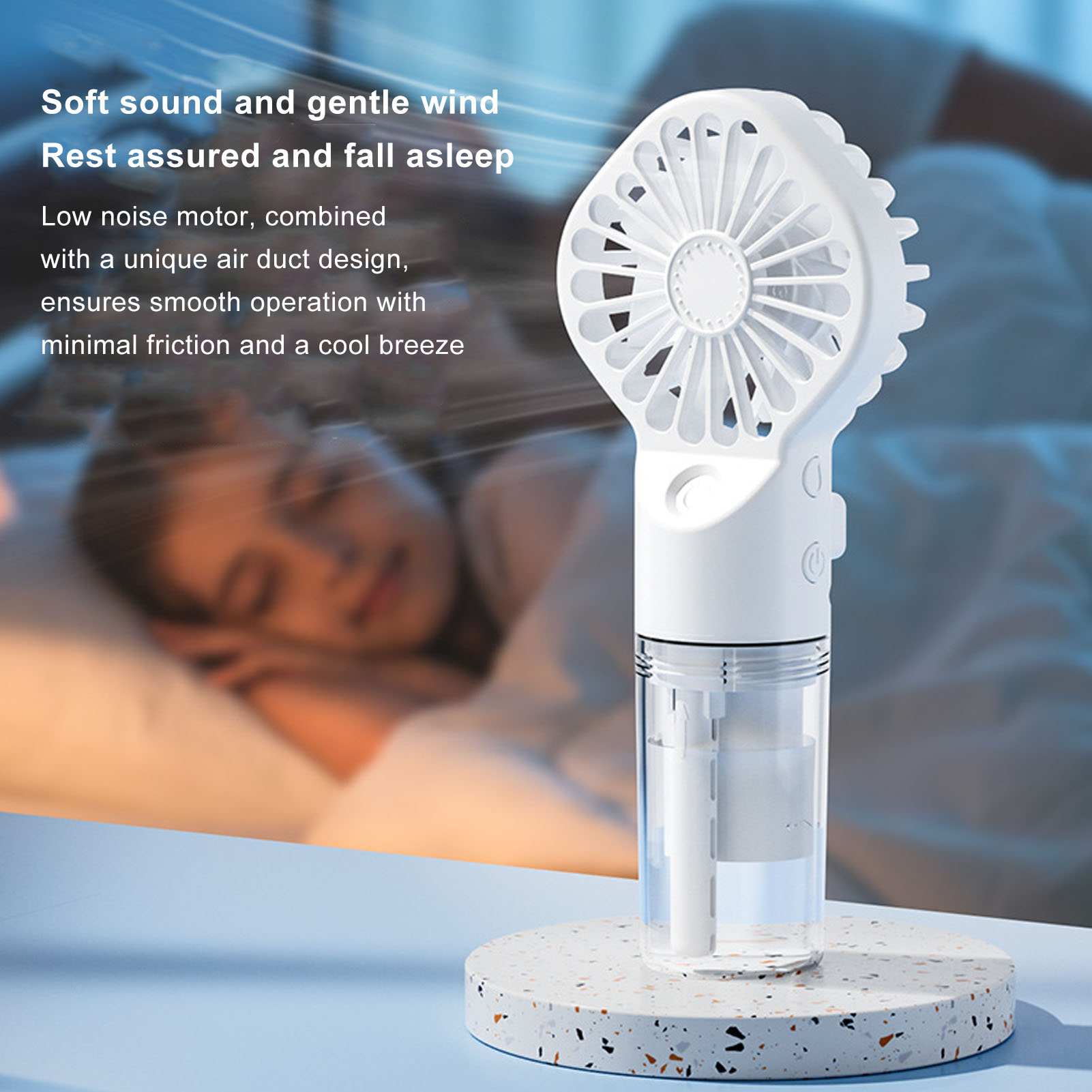 Ein kleiner weißer Ventilator mit Wasserbehälter auf einem Ständer, im Hintergrund eine schlafende Person.