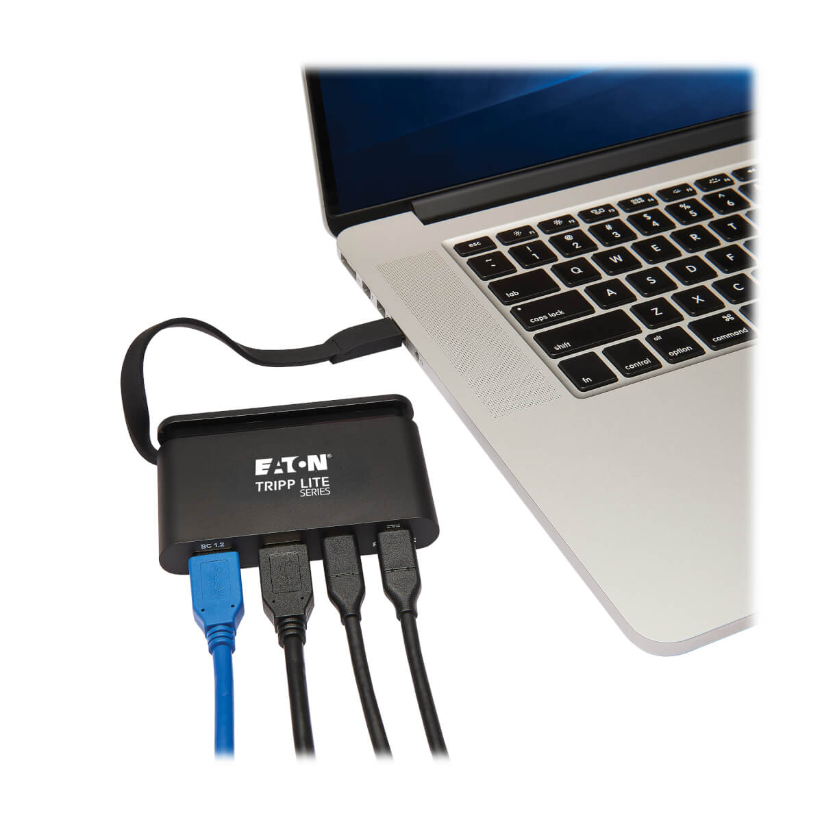 Una computadora portátil conectada a un concentrador negro con múltiples puertos USB y HDMI, varios cables visibles.