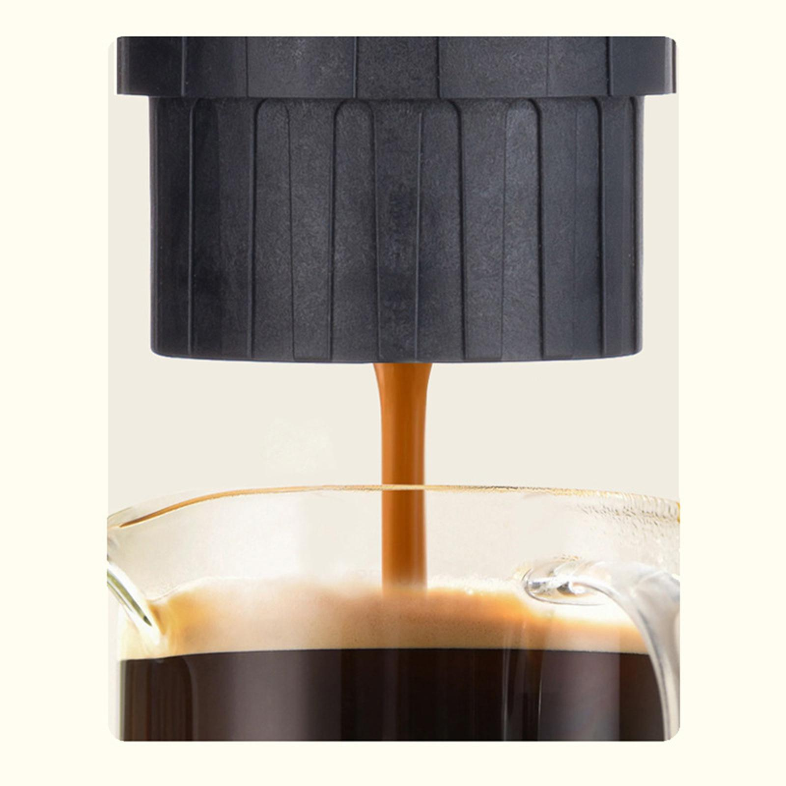 Kaffee gießt aus einem schwarzen Gerät in eine klare Glaskaraffe. Der Kaffee ist dunkelbraun.