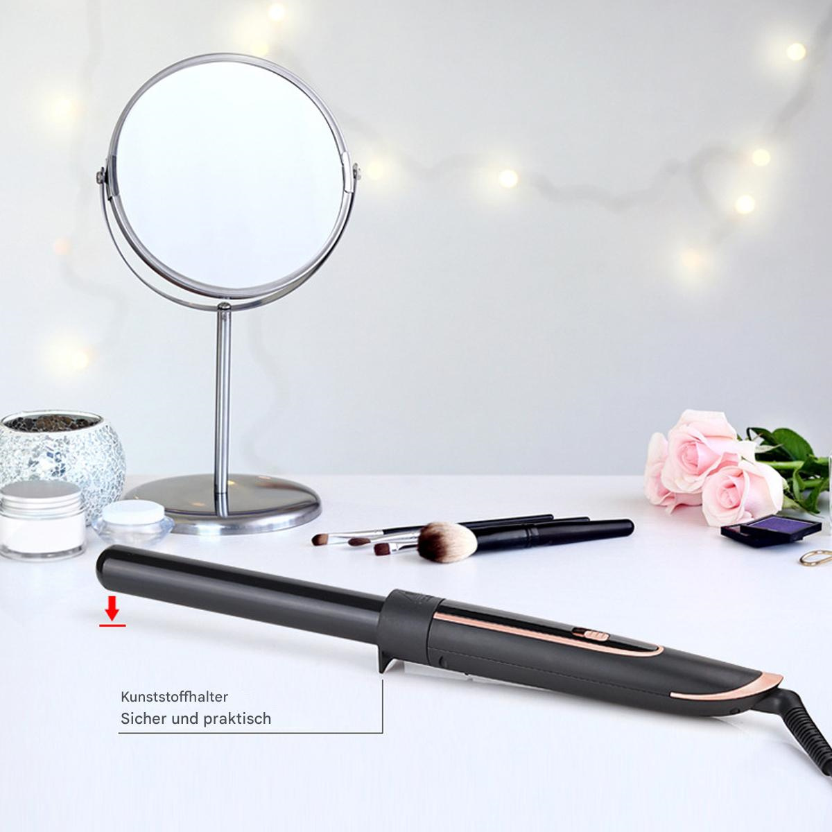 Ein Lockenstab auf einem weißen Tisch. Ein Spiegel, Make-up-Pinsel und Blumen sind ebenfalls sichtbar.