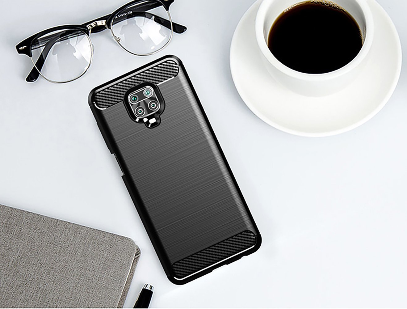 Una funda de teléfono con un teléfono, gafas, una taza de café y un bloc de notas.