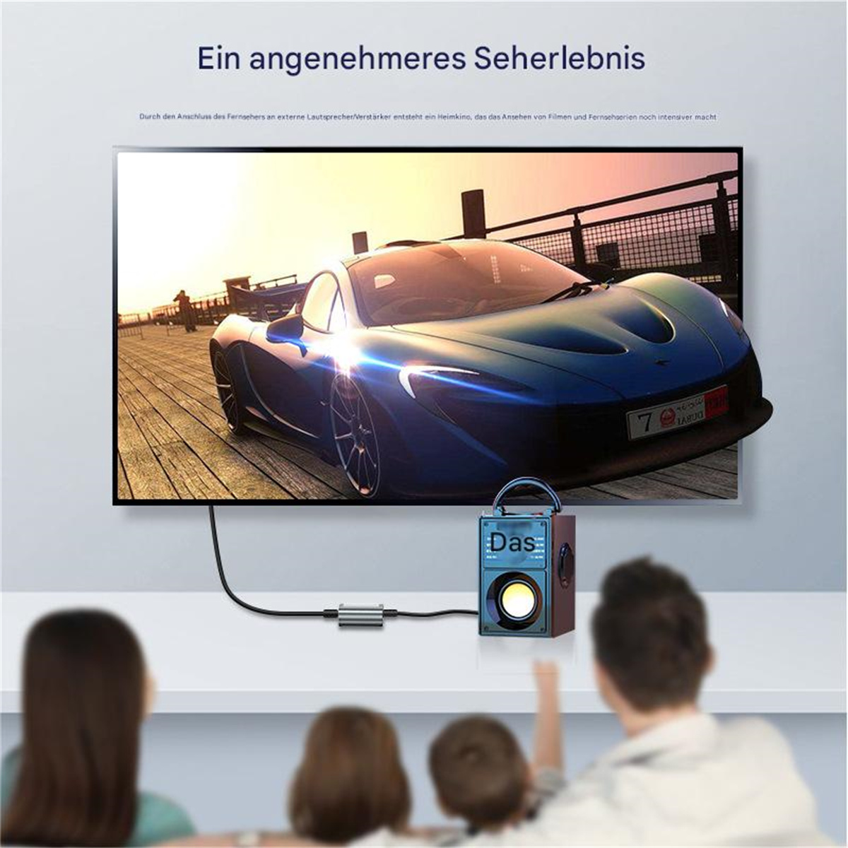 Leute schauen einen Film auf einem Fernseher, der mit einem Lautsprecher und einem Gerät verbunden ist.