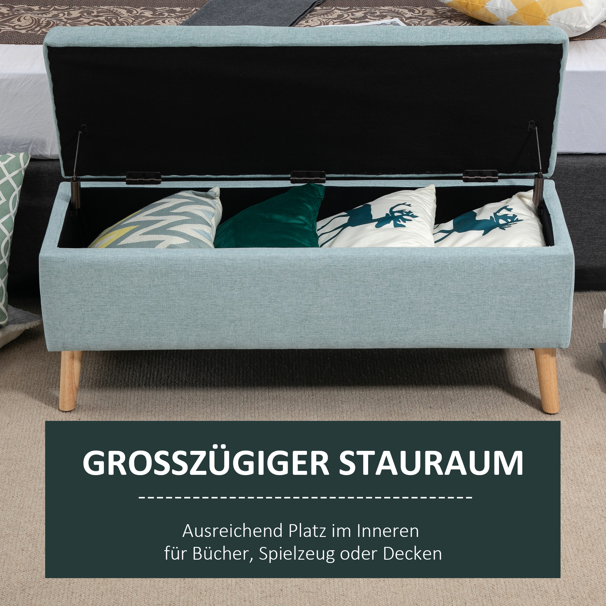 Eine hellblaue Aufbewahrungsbank mit Holzbeinen, die Kissen hält. Der Deckel der Bank ist geöffnet.
