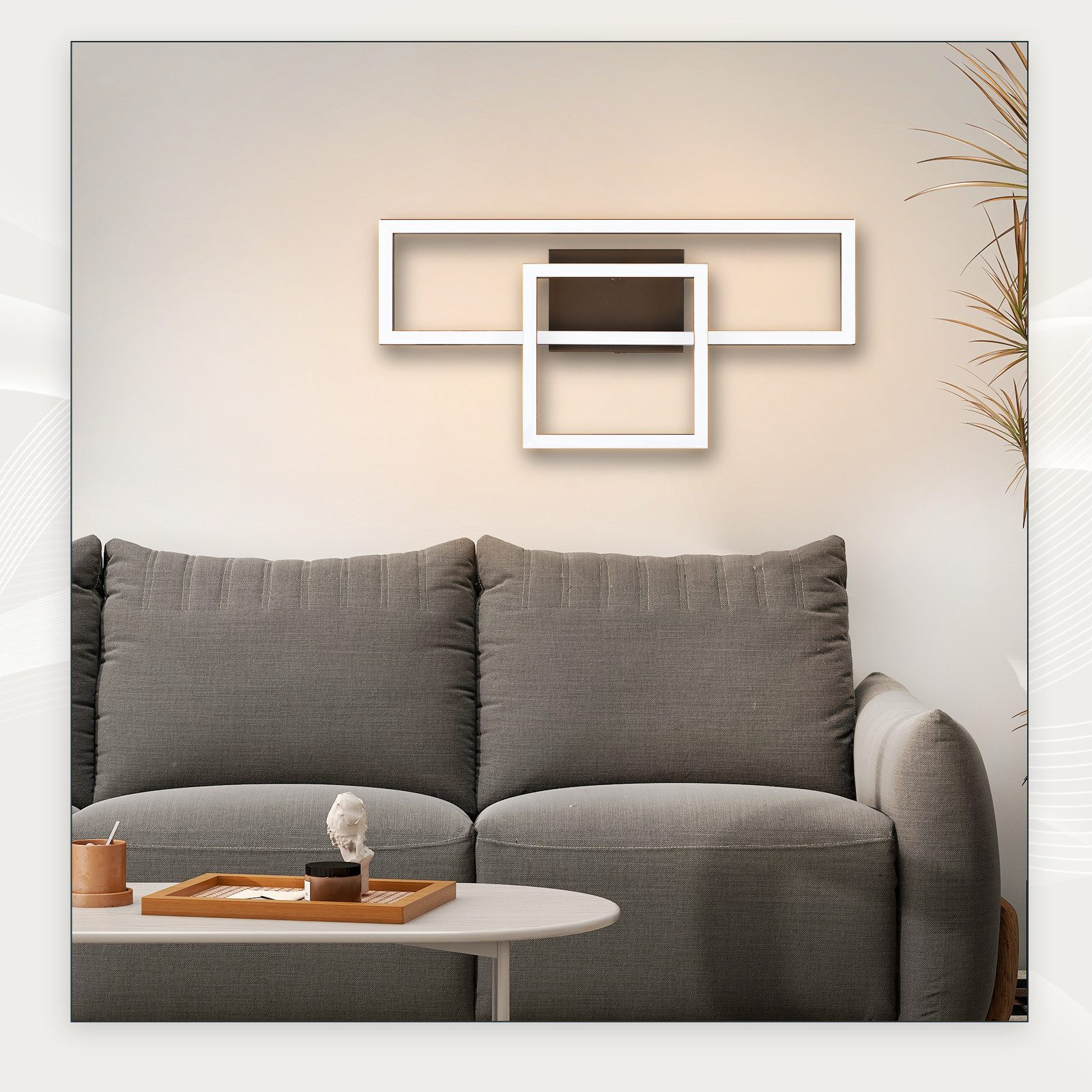 Nowoczesna lampa sufitowa na białej ścianie, nad szarą sofą.