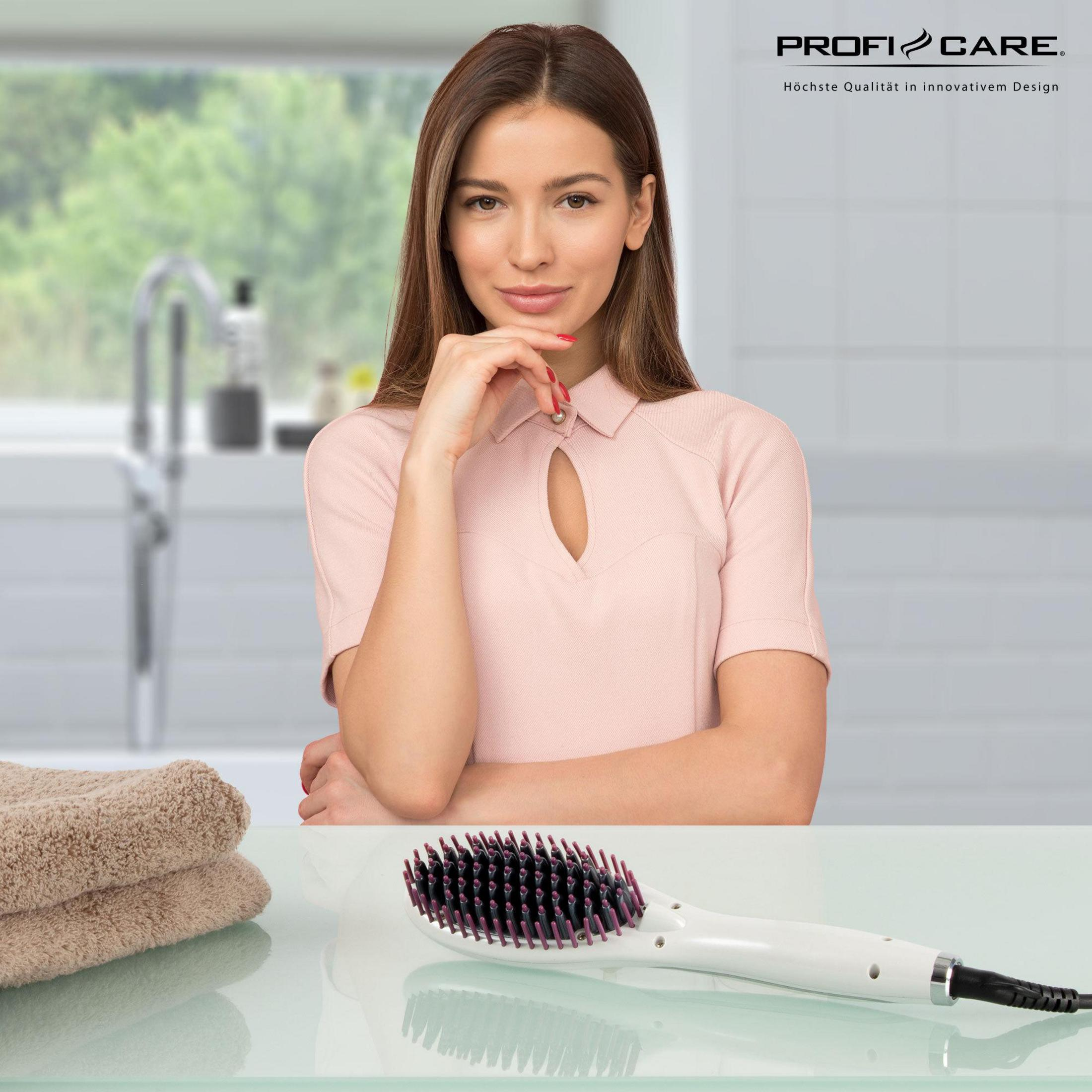 Kobieta z różowym topem, prostownicą do włosów i ręcznikami na stole.