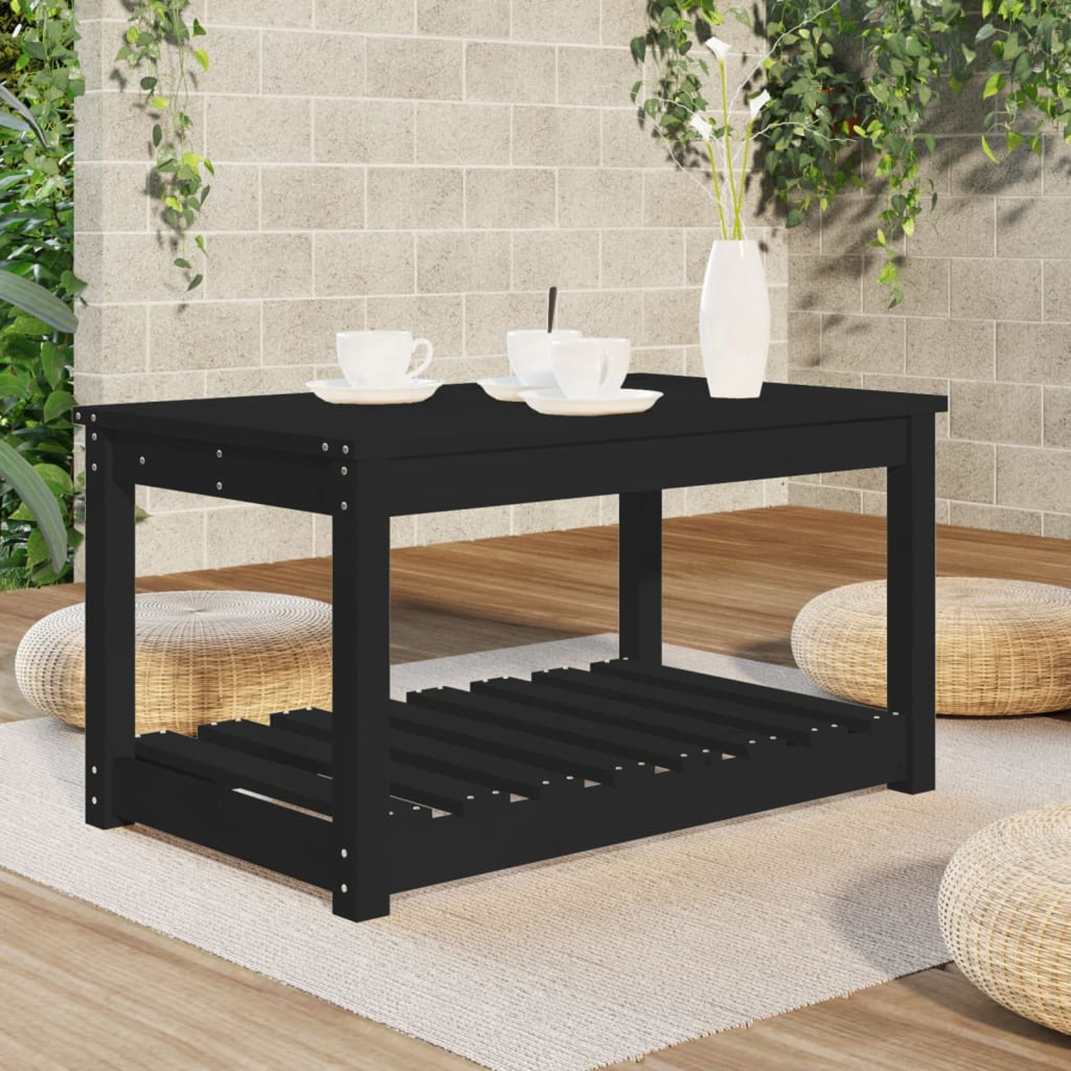 Schwarzer Outdoor-Couchtisch mit Gegenständen darauf.