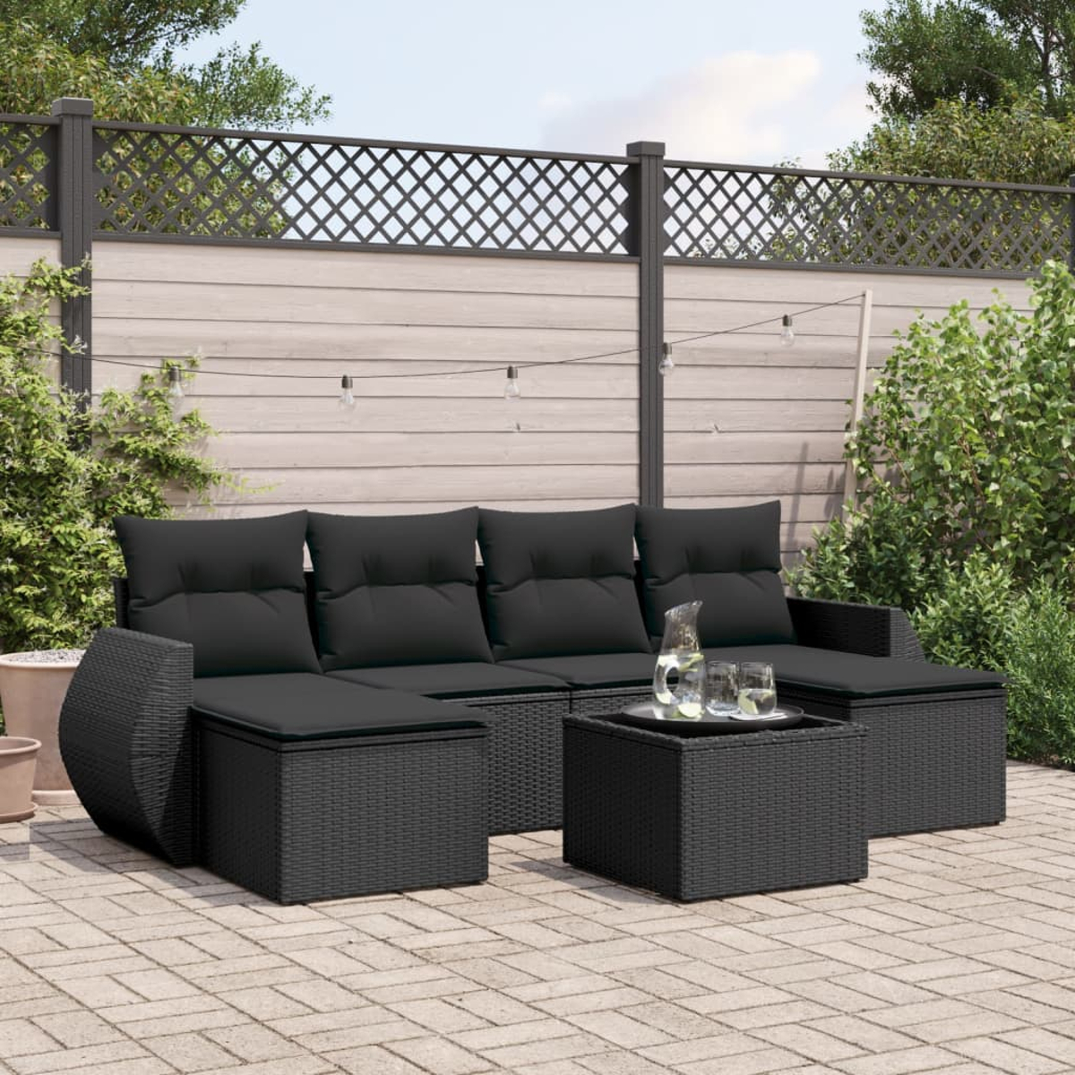 Ein schwarzes Sitzensemble für den Außenbereich. Es umfasst ein Sofa, zwei Ottomanen und einen Couchtisch.
