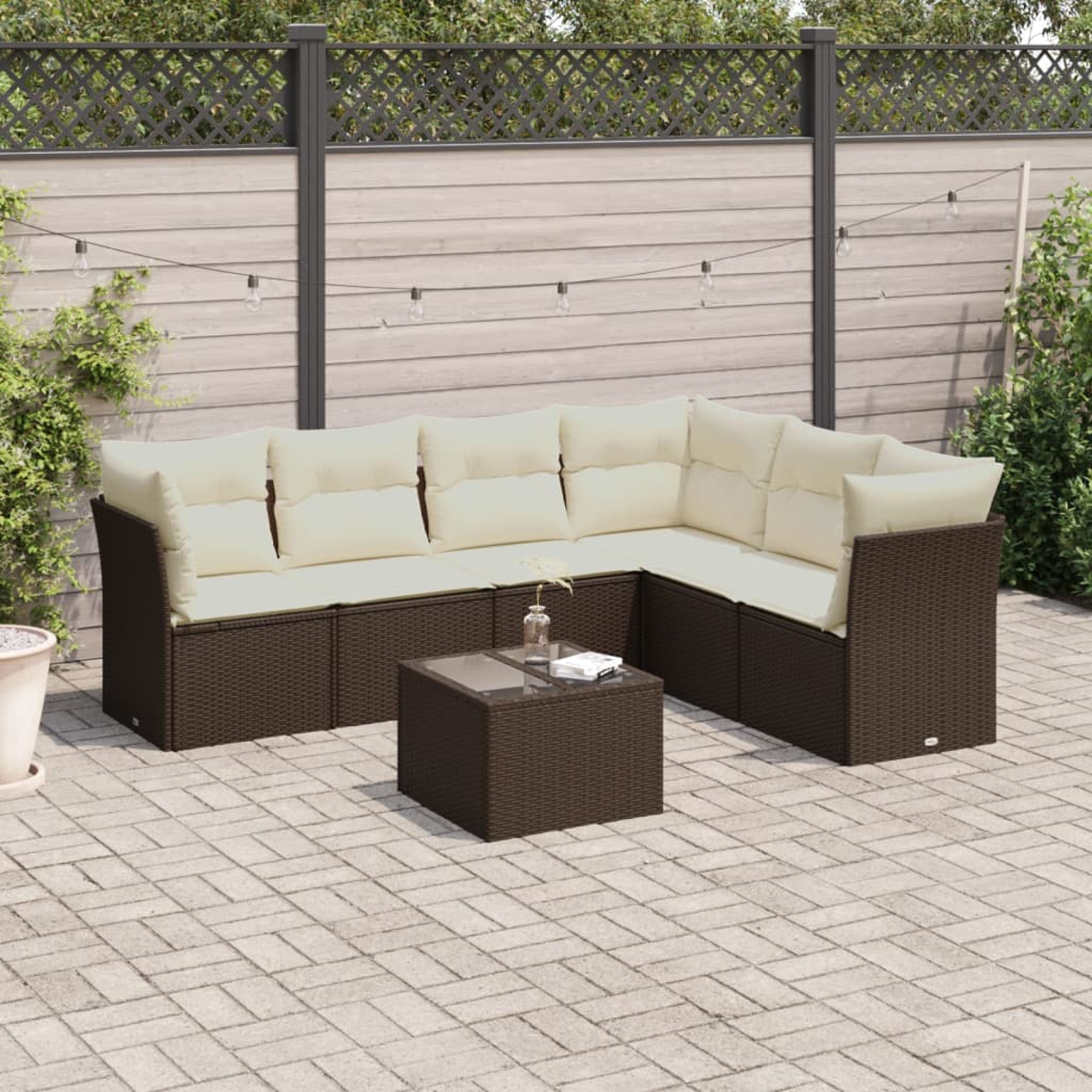 Set di mobili in vimini per esterni. Divano angolare, tavolino. Cuscini beige. Vimini marrone.
