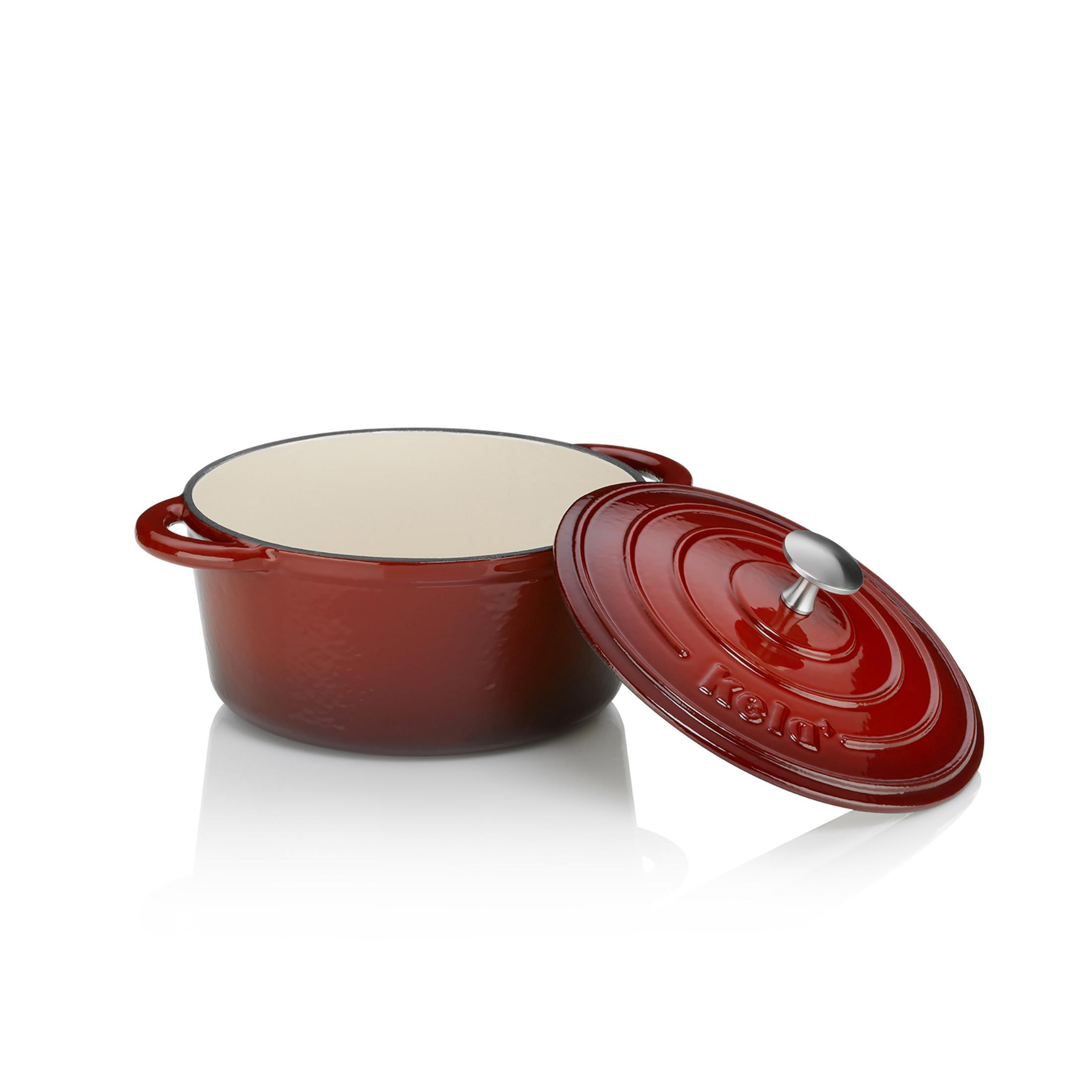 Roter gusseiserner Topf mit abgenommenem Deckel, auf weißer Oberfläche. Innen creme.