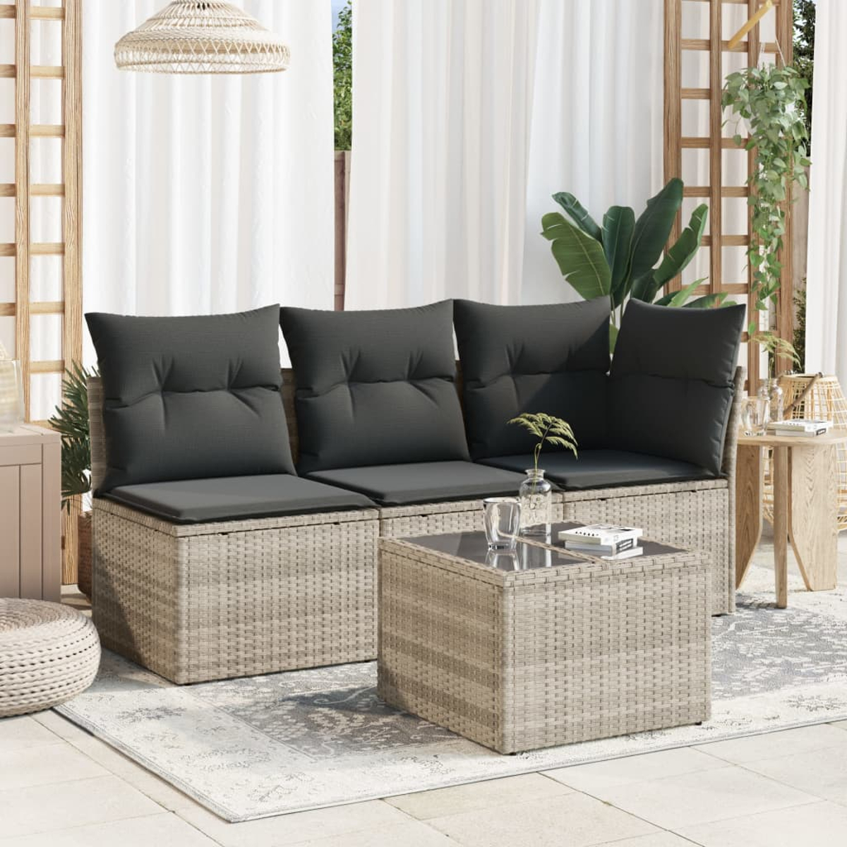 Outdoor-Rattansofa-Set mit grauen Kissen und einem Tisch mit Glasplatte.