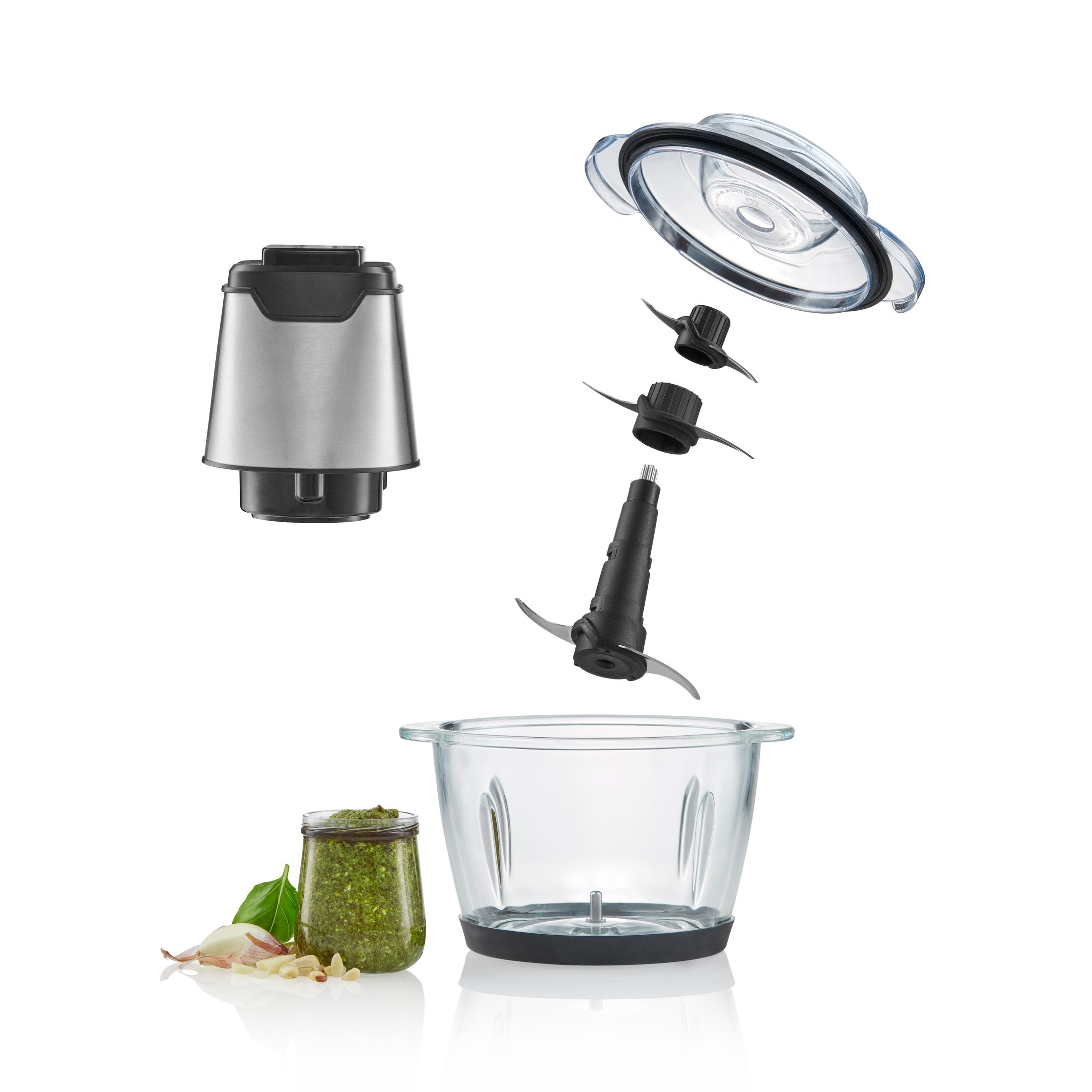 Blenderteile, darunter Klingen, Glasschüssel und Deckel. Pesto und Knoblauch daneben.