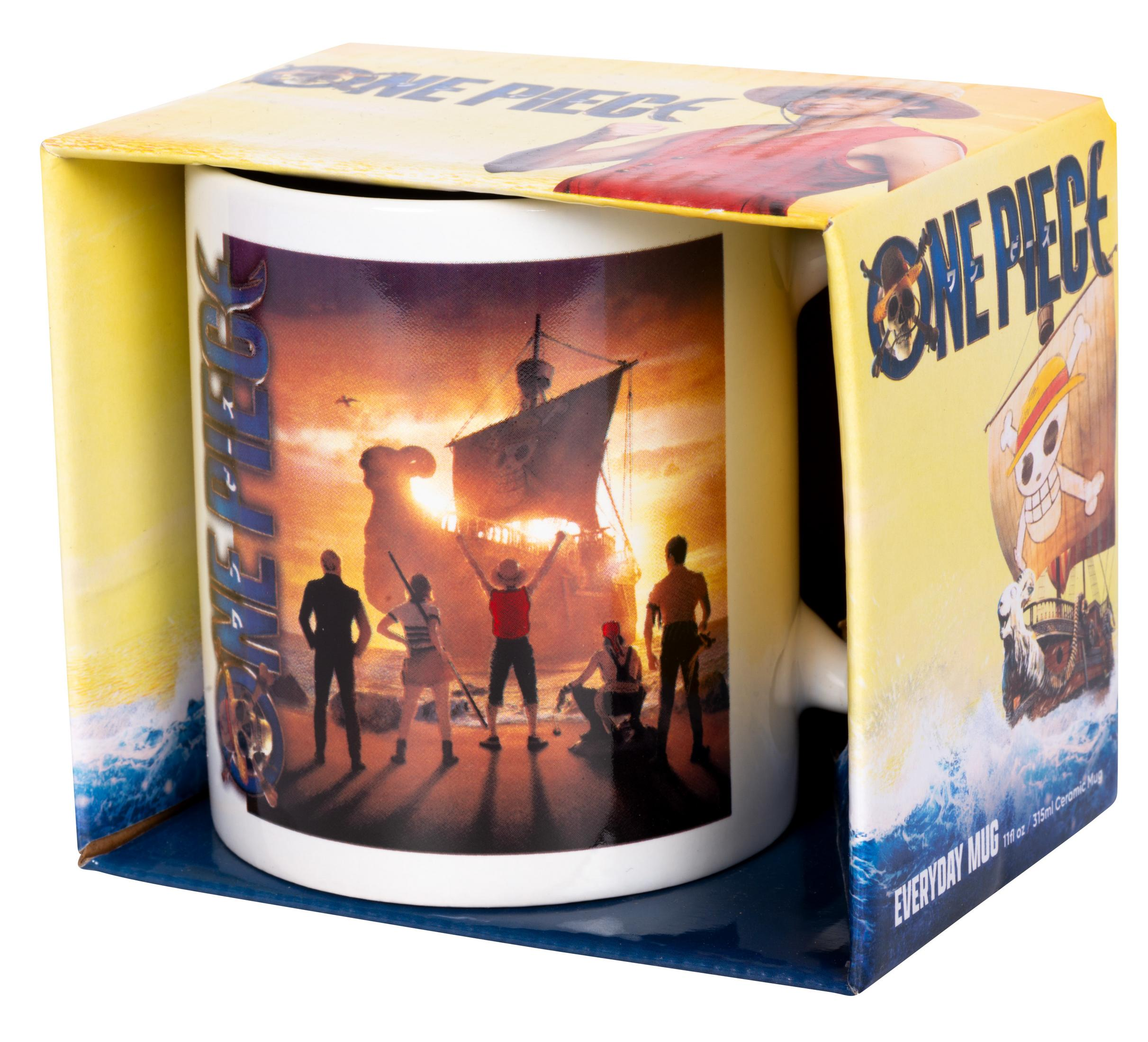 Tasse in einer Schachtel mit One Piece-Charakteren darauf. Die Tasse ist weiß und hat einen schwarzen Griff.