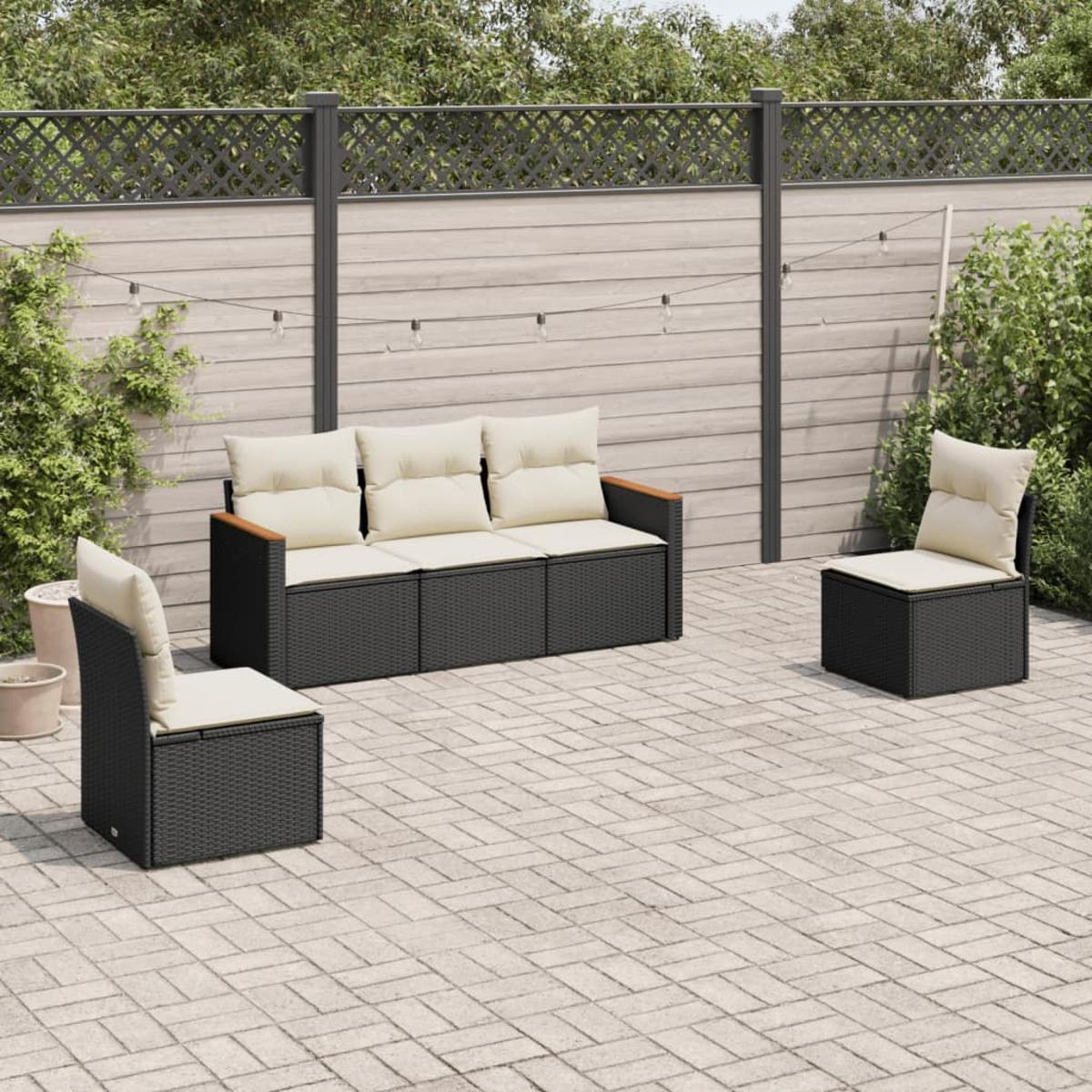 Arredamento per patio con mobili da esterno: un divano, due sedie e un tavolo, su una superficie in mattoni.