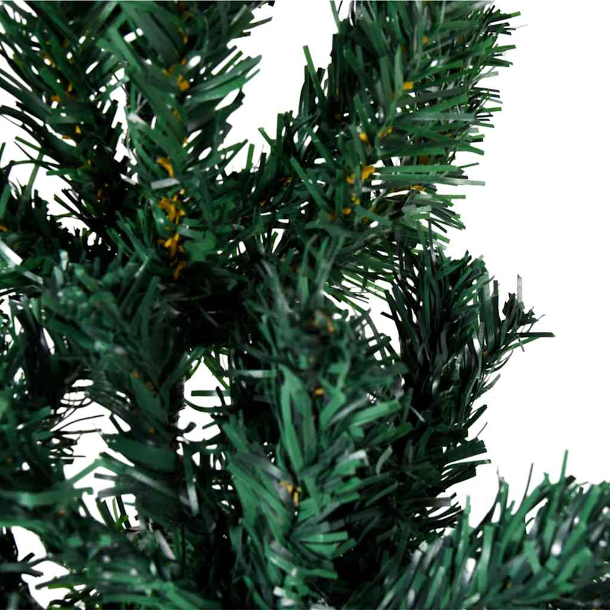 Nahaufnahme eines grünen künstlichen Weihnachtsbaums. Nadeln und Äste sind sichtbar.