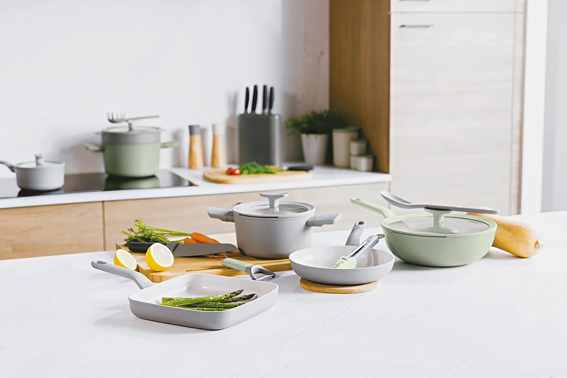 Keuken met kookgerei, groenten en keukengerei op een houten aanrecht.
