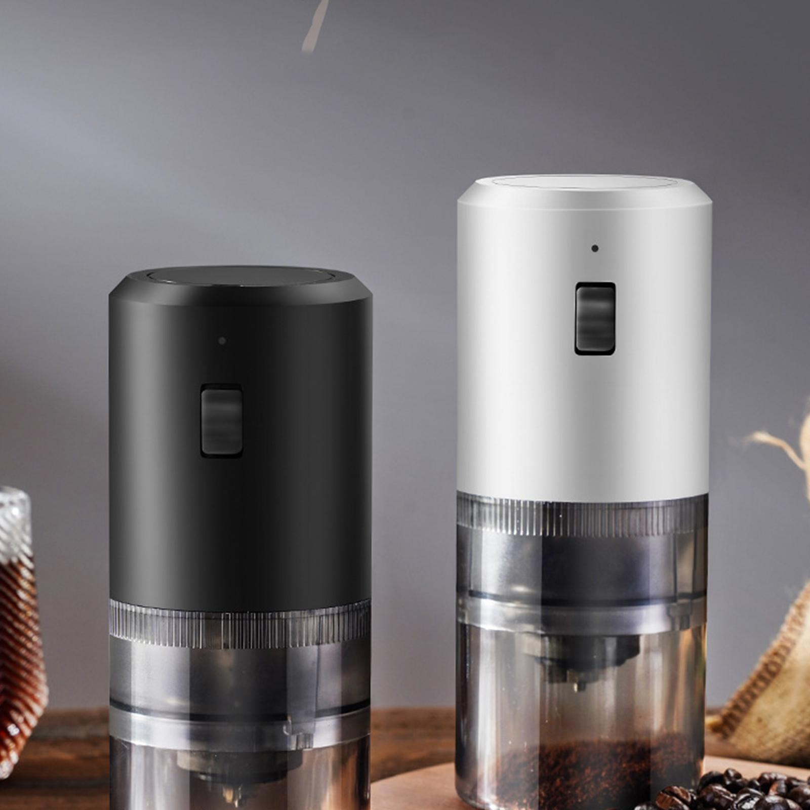 Zwei elektrische Kaffeemühlen in Schwarz und Weiß, eine mit Bohnen, eine mit gemahlenem Kaffee.