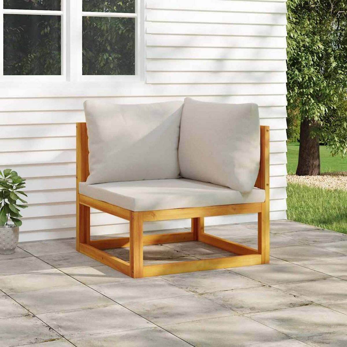 Holz-Außenstuhl mit Kissen und Kissen auf einer Terrasse, neben einem Haus.