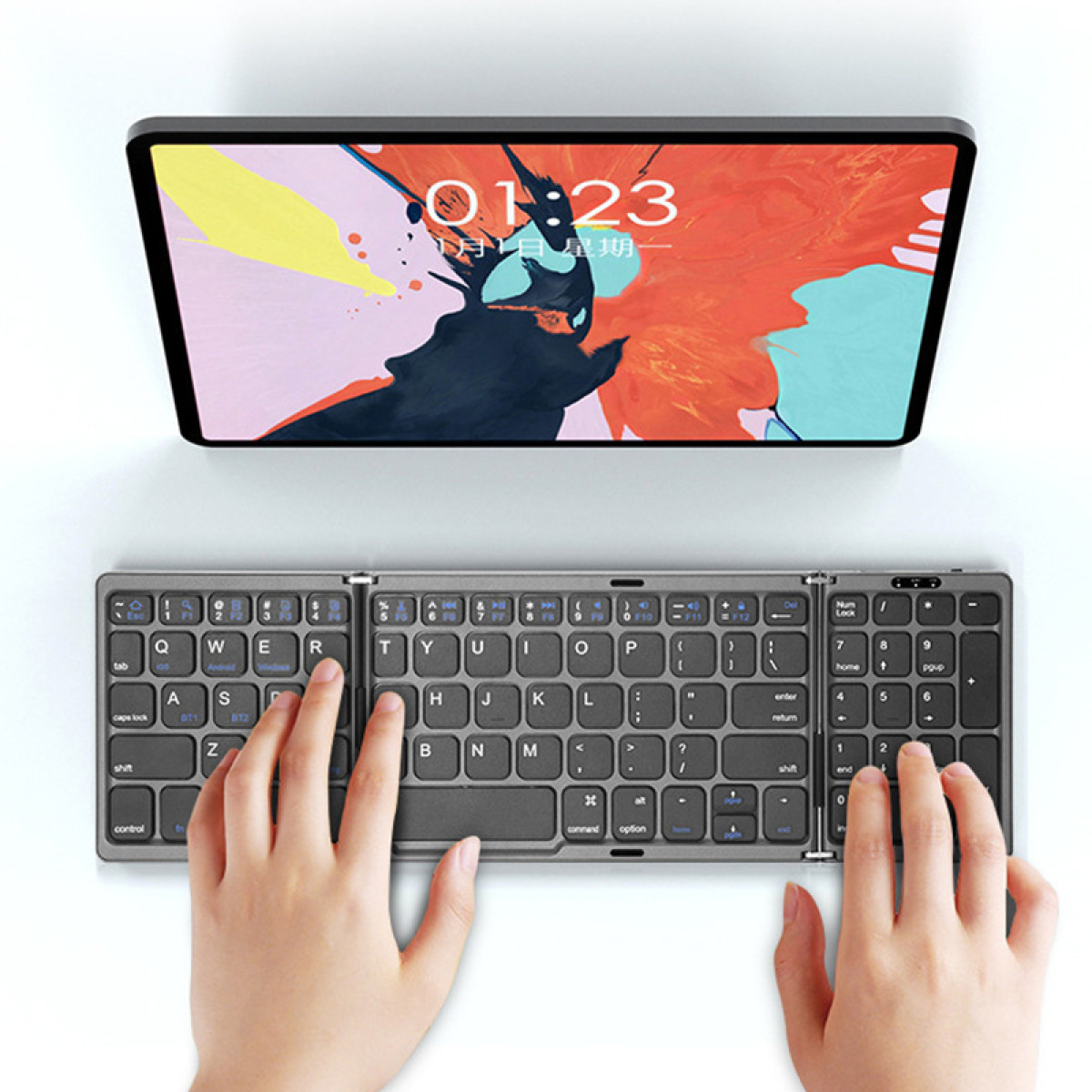 Eine Person benutzt eine Tastatur. Ein Tablet befindet sich über der Tastatur.