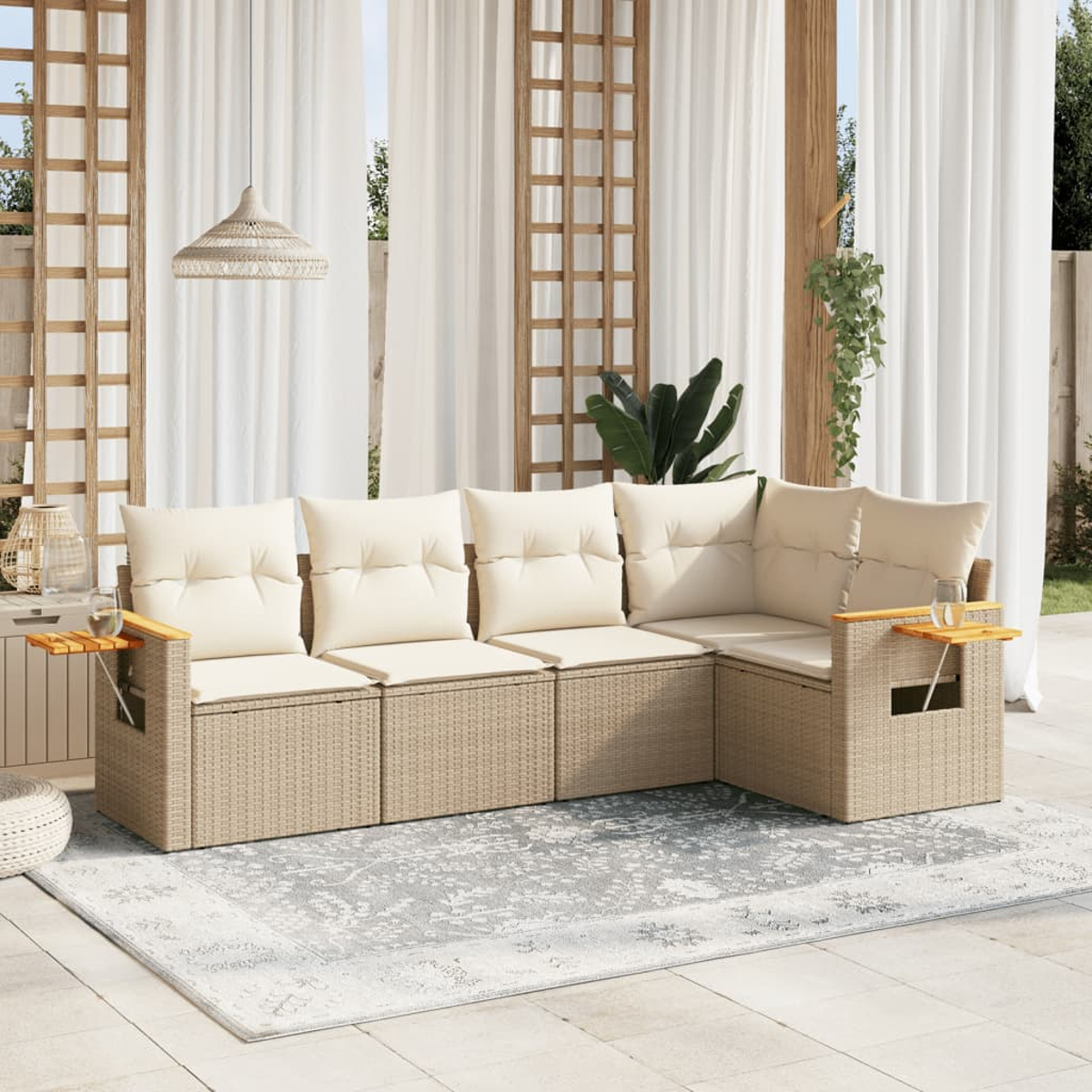 Beiges Rattan-Outdoor-Sofa mit Kissen und Beistelltischen, auf einem grauen Teppich, mit weißen Vorhängen.