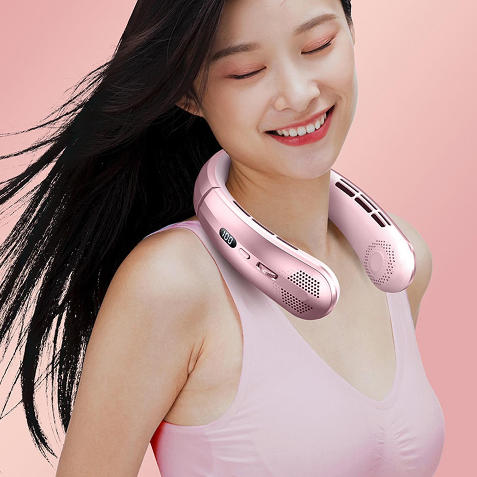 Frau mit pinkfarbenem Nackenventilator. Sie lächelt, hat dunkles Haar und ein pinkfarbenes Oberteil.