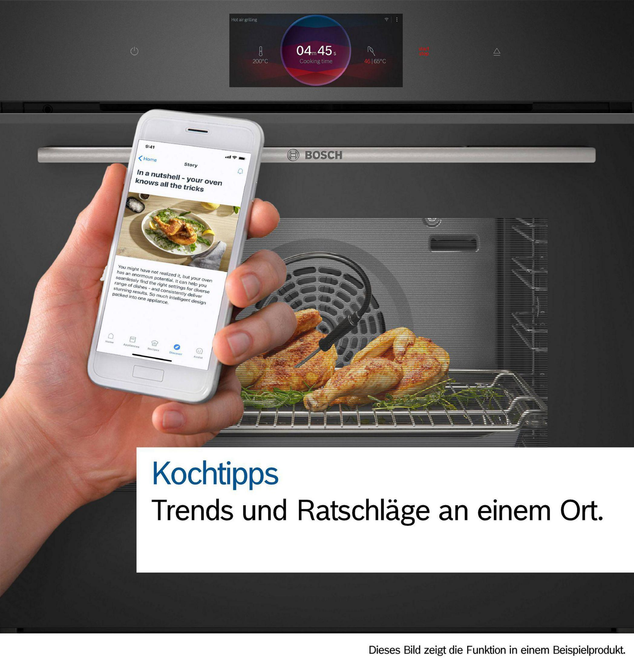 Person hält Telefon mit Backofendisplay, darauf gebratenes Hähnchen, vor einem Ofen.