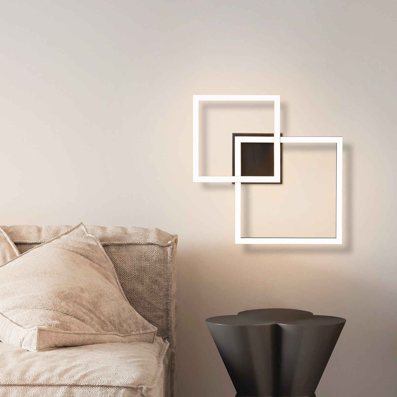Lampada da parete moderna con due quadrati sovrapposti. La lampada è bianca con un quadrato nero al centro.