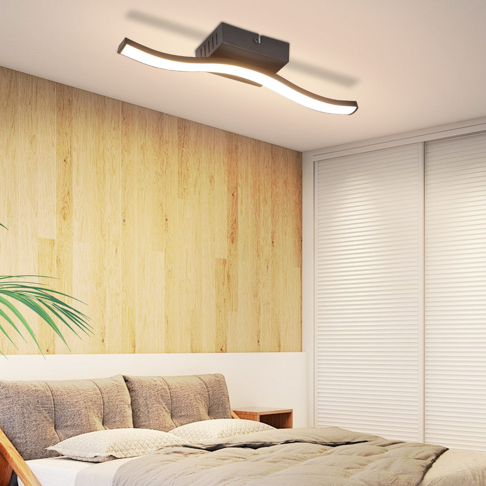 Scena di camera da letto moderna con luce a soffitto curva, parete in legno e letto con cuscini e piumino.