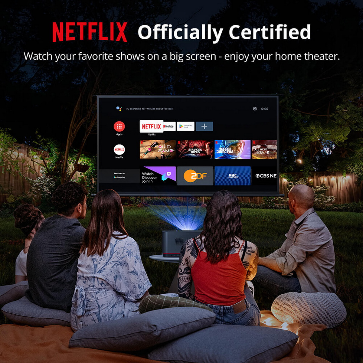 Eine Gruppe von Menschen schaut sich im Freien einen Film auf einem Projektor an. Der Bildschirm zeigt Netflix.
