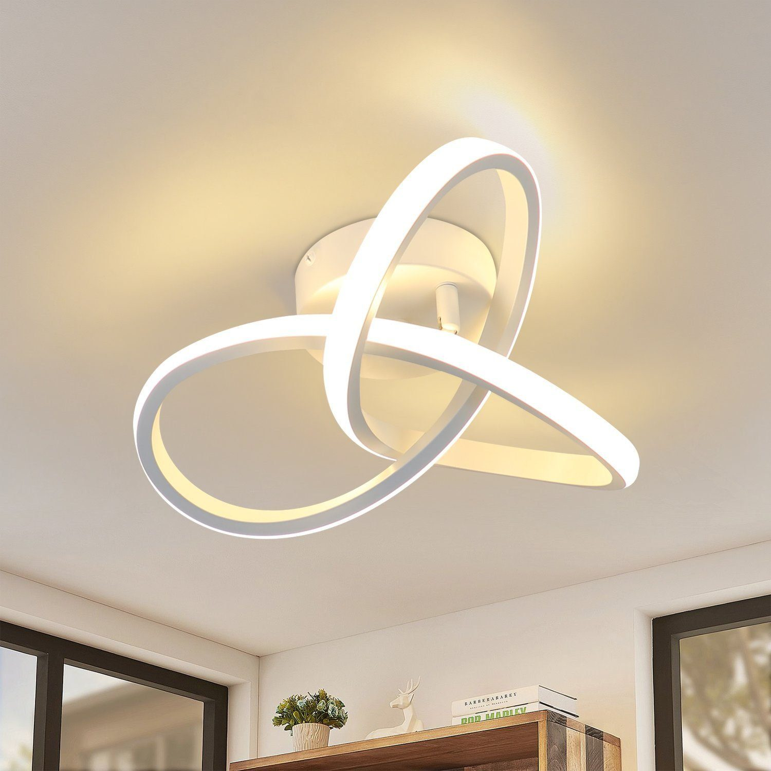 Biała lampa sufitowa o unikalnym designie. Tło obejmuje biały sufit i półkę.