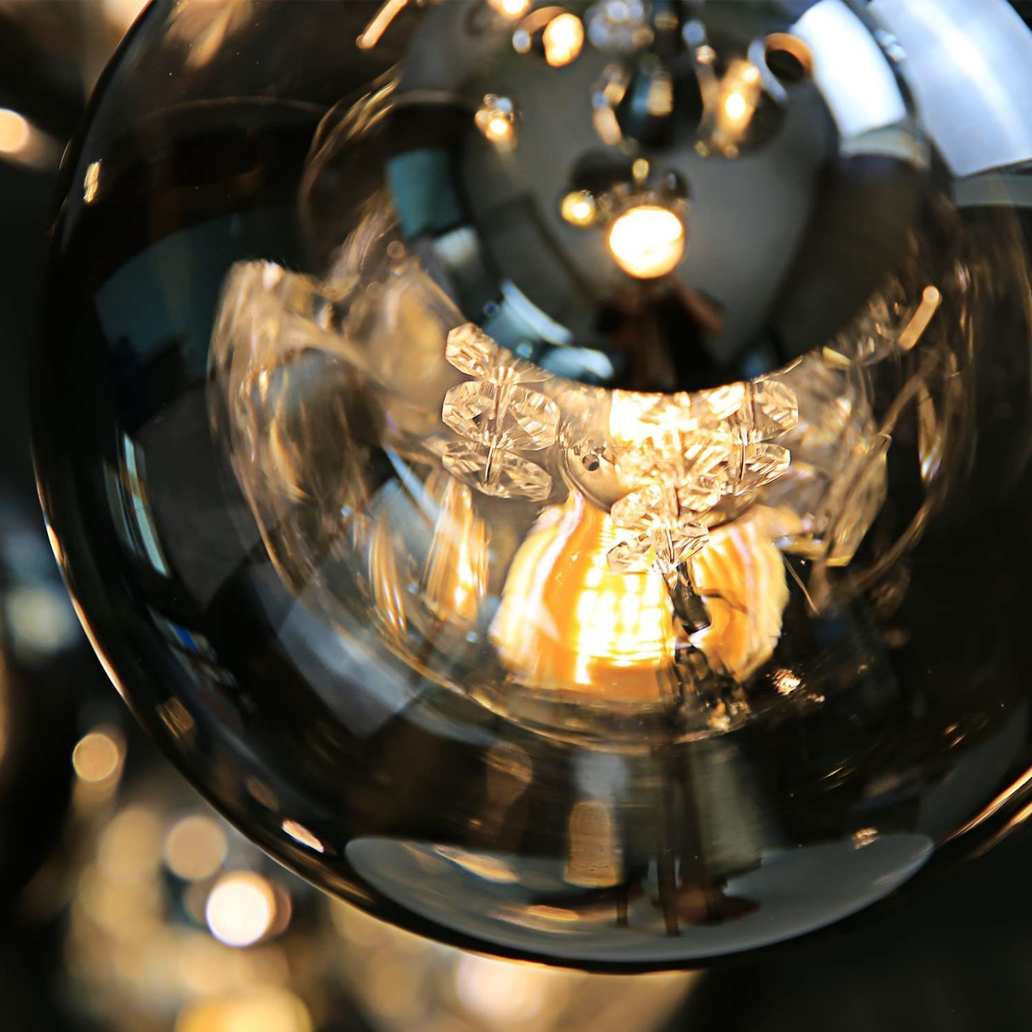 Nahaufnahme einer Glaskugel, die eine Leuchte reflektiert, mit weichem, verschwommenem Hintergrund.