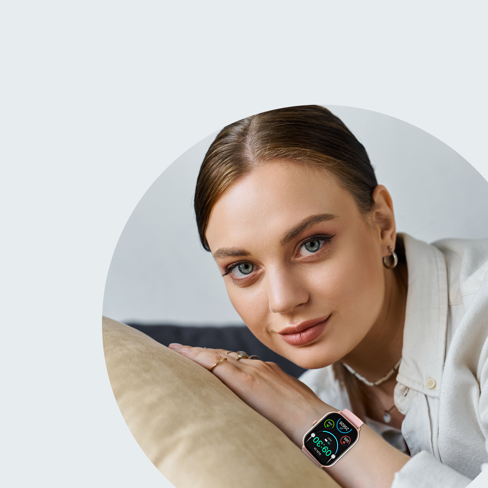 Vrouw met smartwatch met roze band, leunt op een bank.