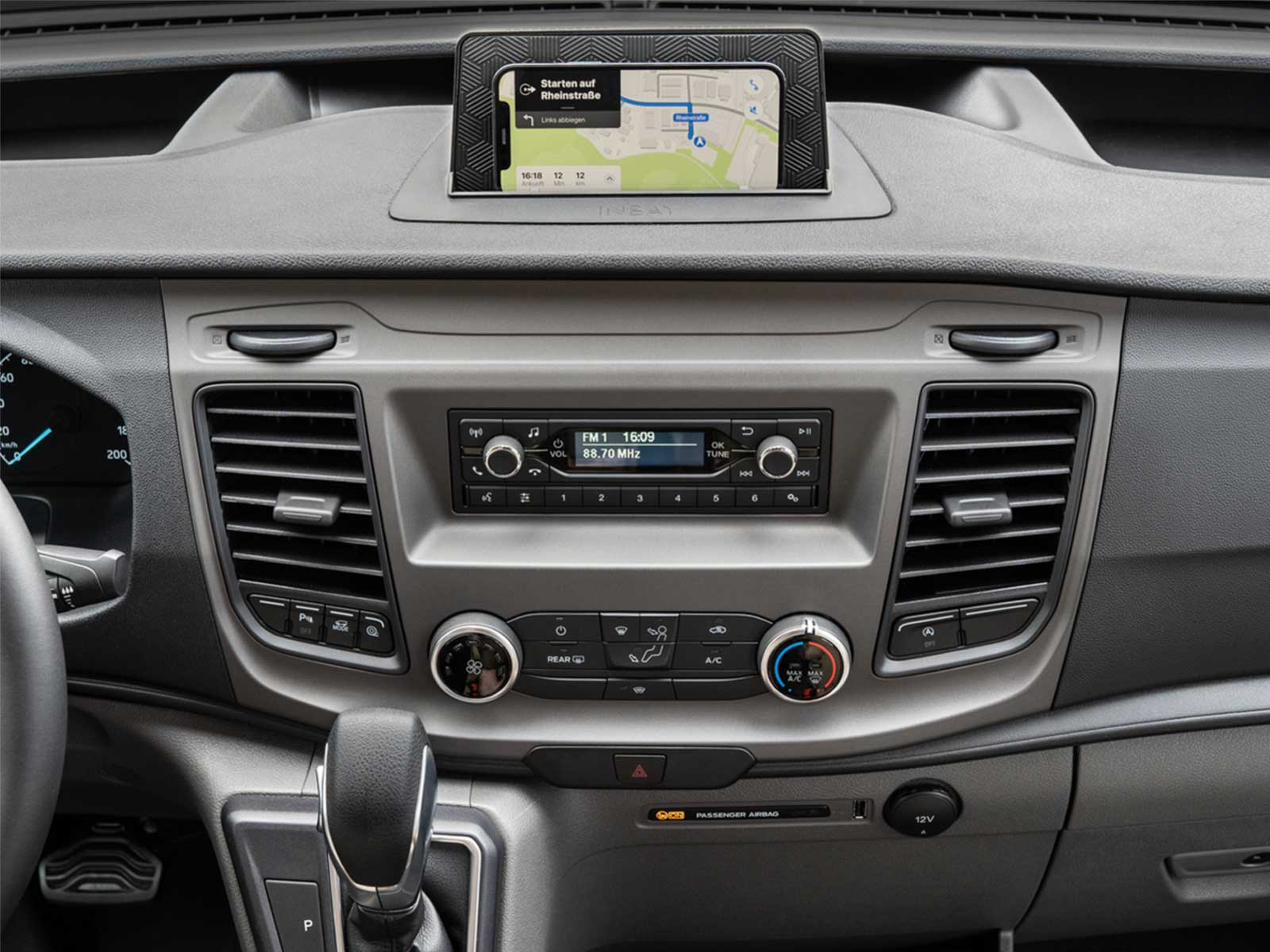 Das Armaturenbrett eines Autos mit GPS-Anzeige, Radio, Lüftungsschlitzen und Klimaanlage.