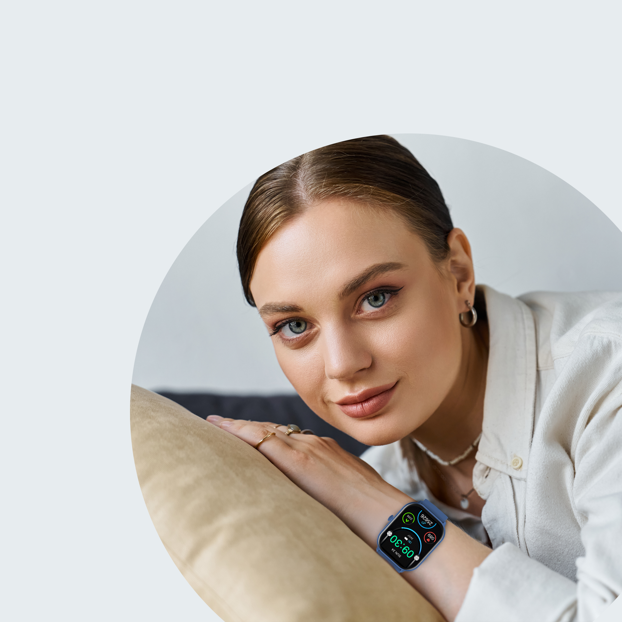 Vrouw met smartwatch, glimlachend, leunt op een bank.