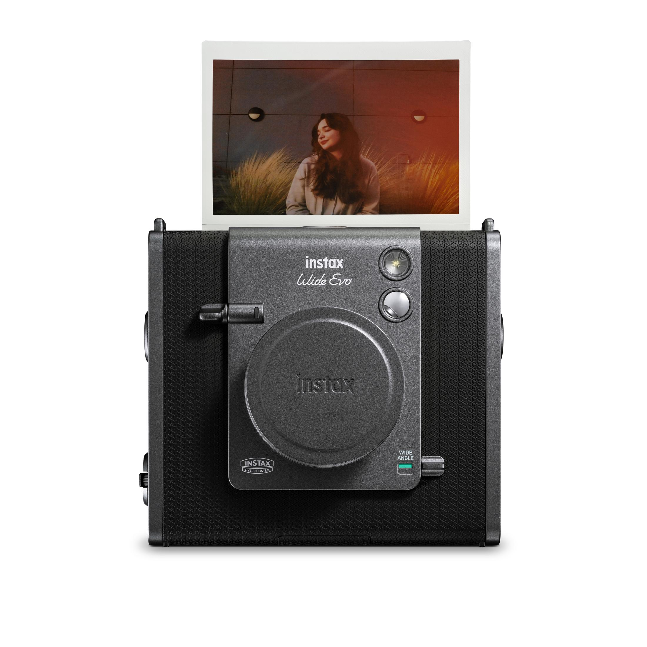 Instax Kamera, die ein Foto auswirft, isoliert auf weißem Hintergrund.