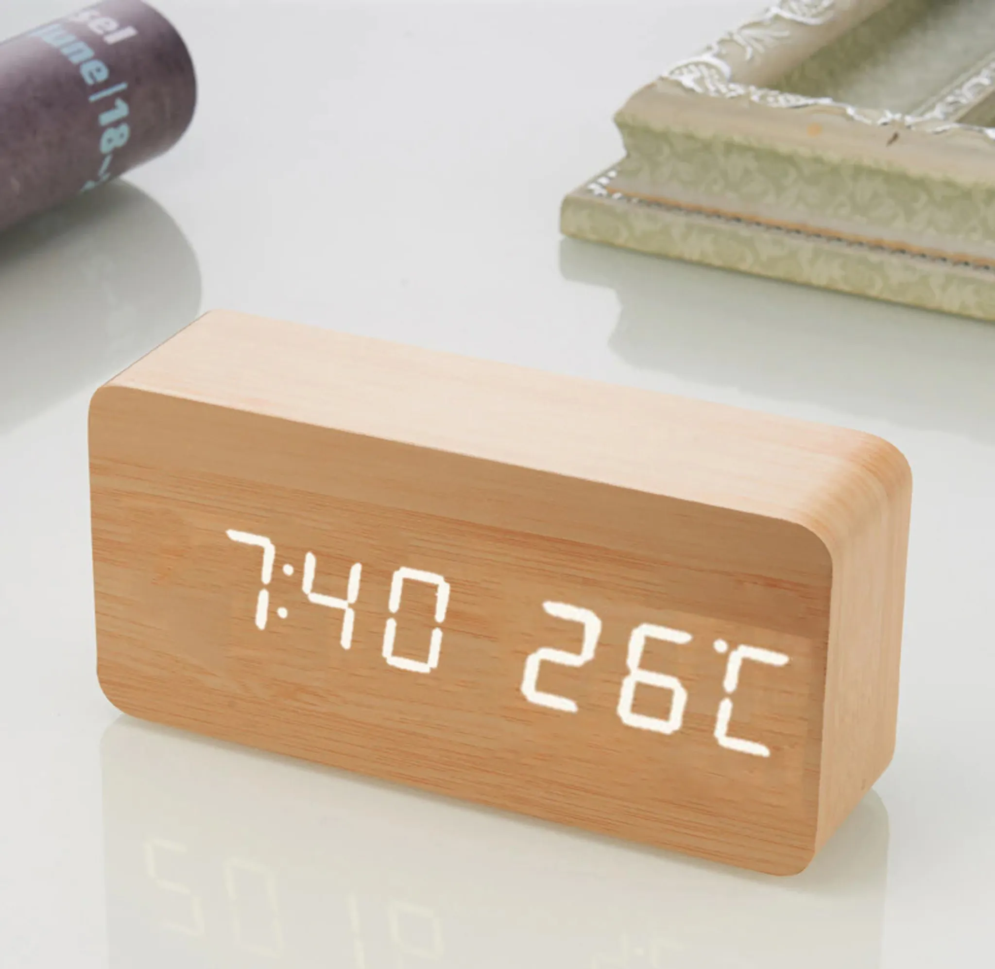Digitaluhr aus Holz mit der Anzeige 7:40 und 26°C. Sie hat einen Holzrahmen und eine digitale Anzeige.