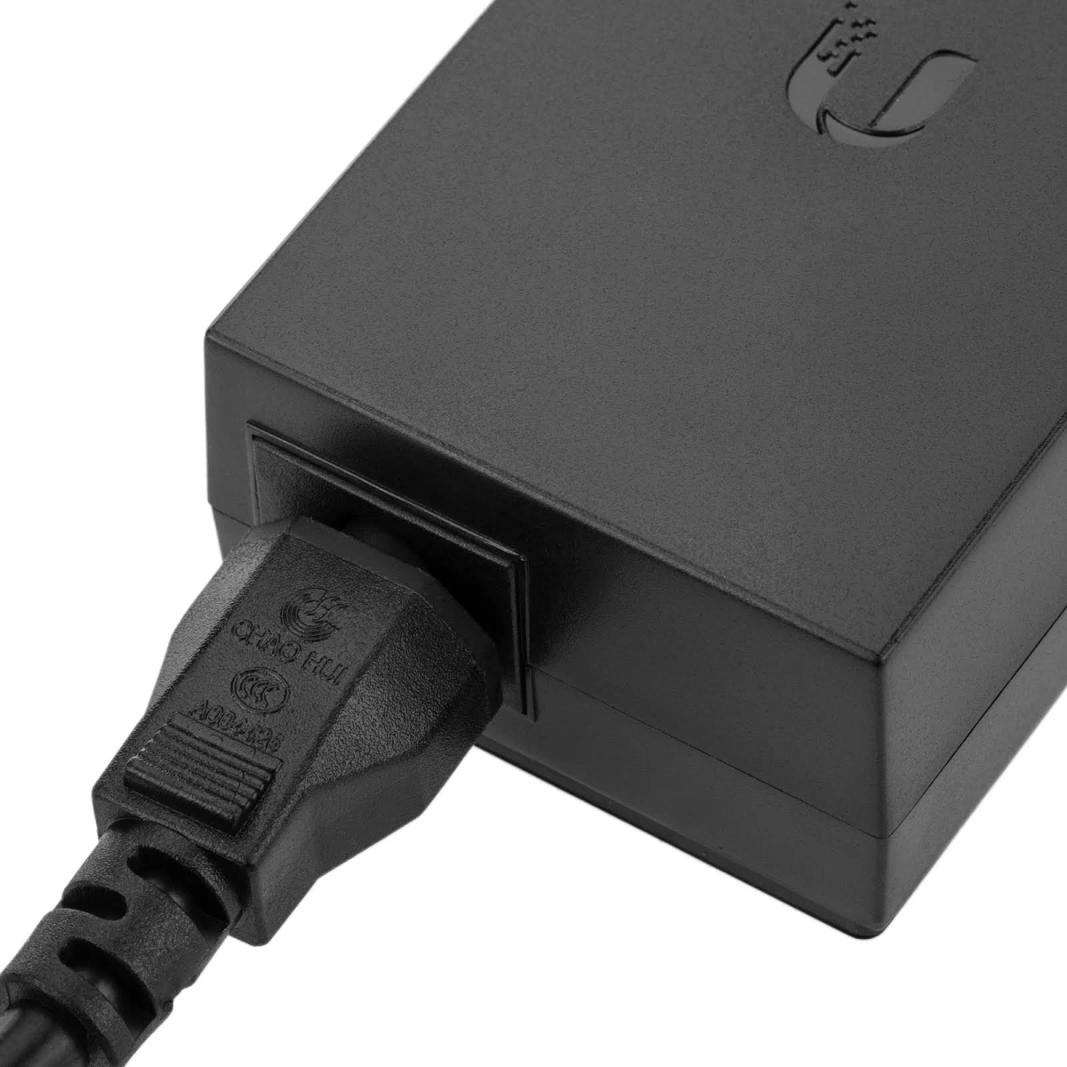 Zbliżenie kabla zasilacza podłączonego do czarnego adaptera.