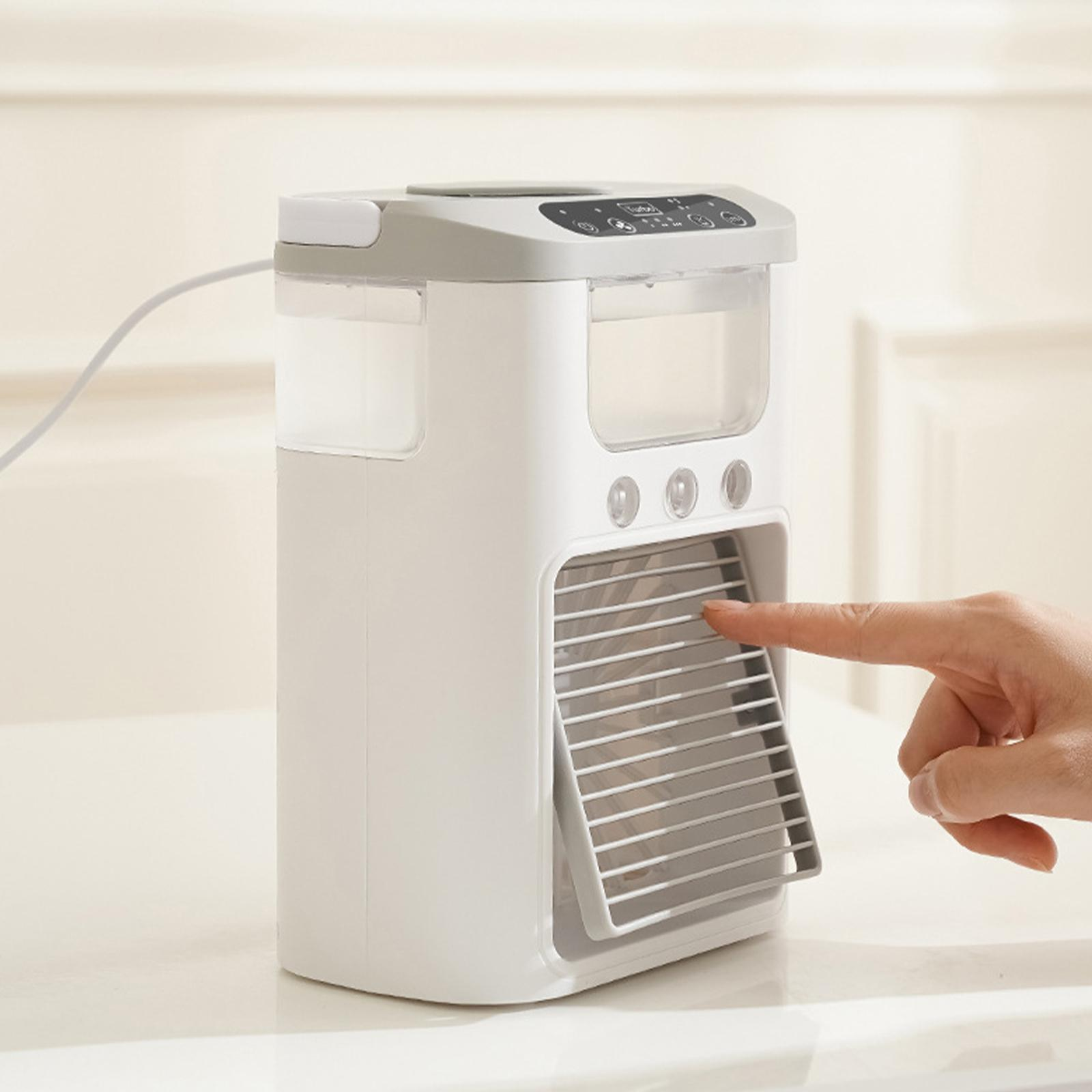 Ein weißer tragbarer Klimaanlage. Ein Finger zeigt auf die Lüftung.