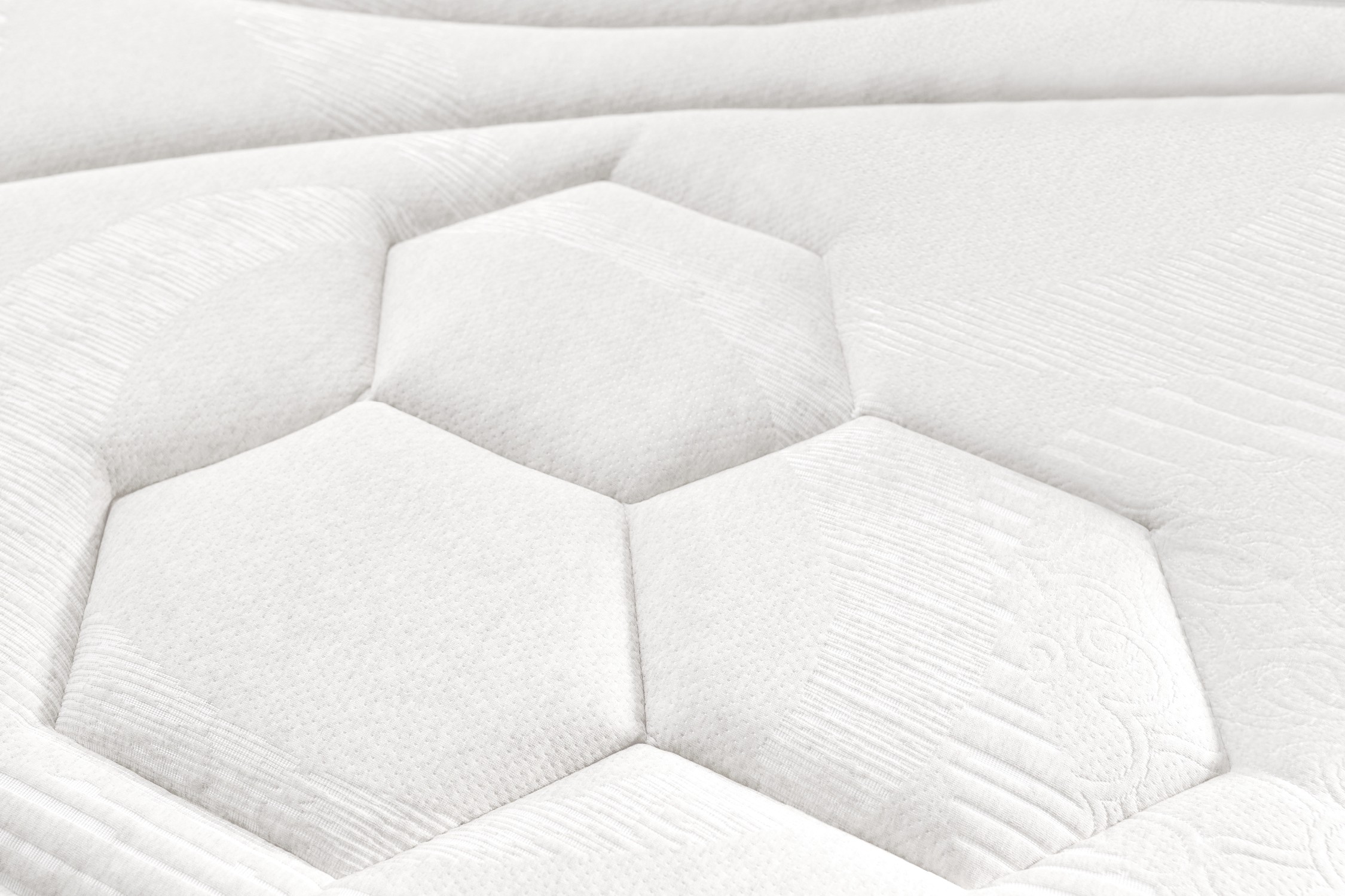 Primer plano de la superficie blanca del colchón con patrón hexagonal.