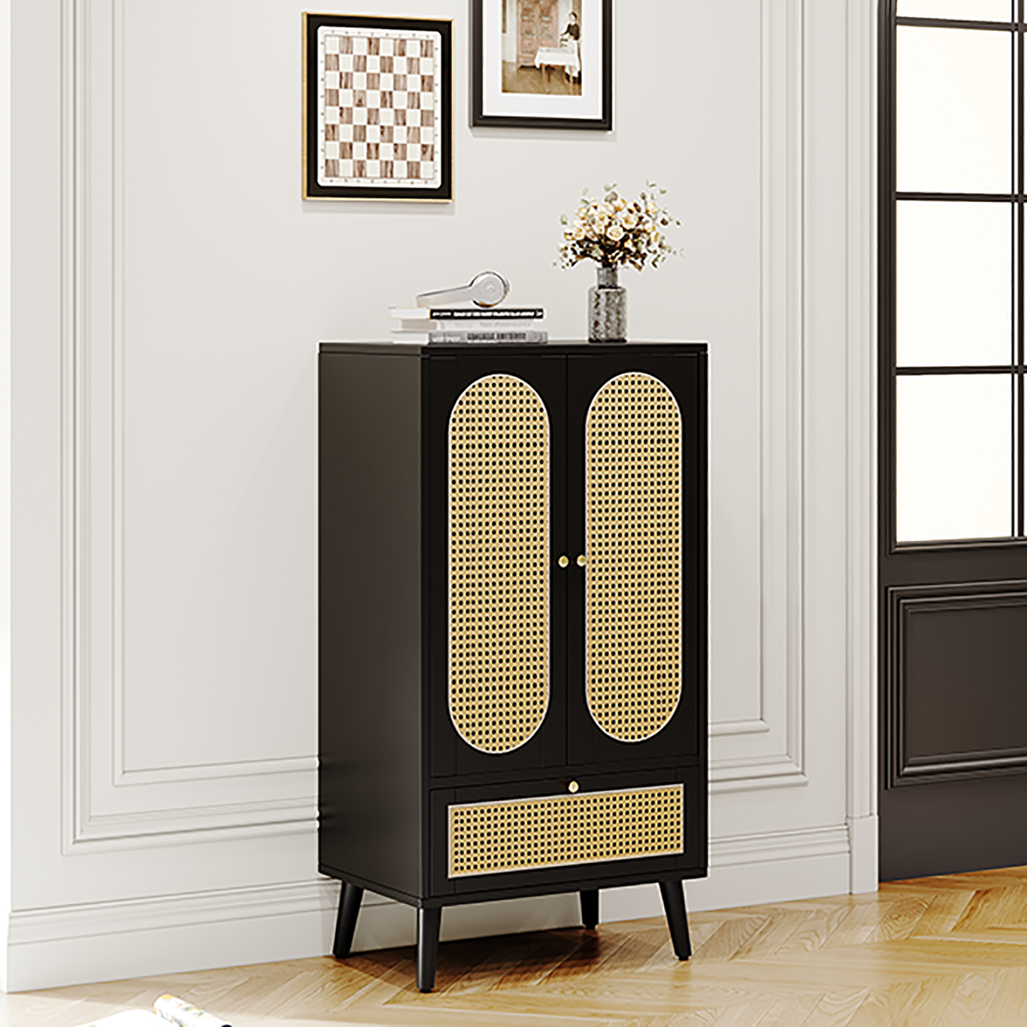 Schwarzer Schrank mit Türen und Schublade aus gewebtem Rohrgeflecht. Eine Blumenvase steht oben drauf.