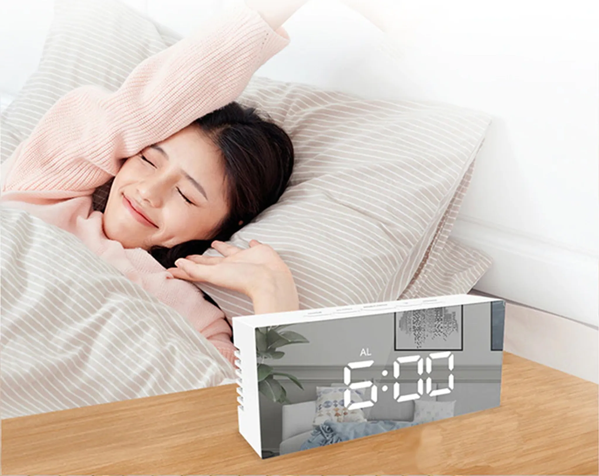 Eine Frau im Bett lächelt einen Spiegeluhr auf einem Nachttisch aus Holz an um 6:00 Uhr morgens.